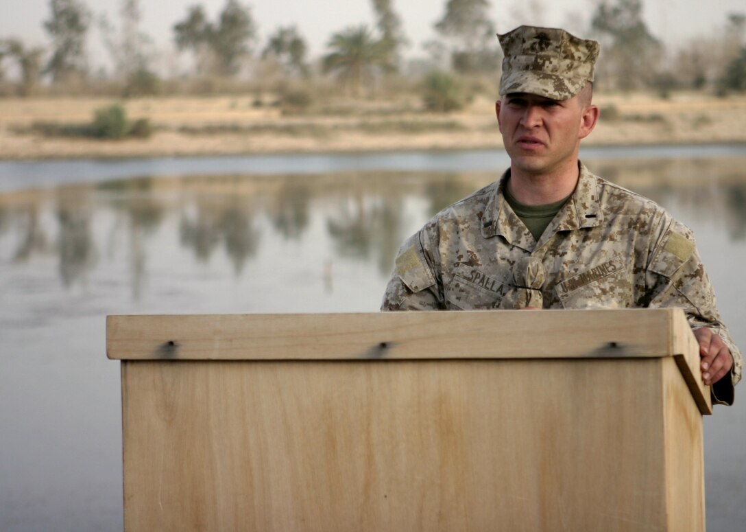 CAMP BAHARIA, Iraq - 1st Lt. Robert Spalla, 2nd Platoon, Company A, 2nd Combat Engineer Battalion platoon commander, commemorates the lives of Lance Cpl. Mario Castillo and Lance Cpl. Andrew Kilpela during a memorial service here June 12.  The two engineers passed away June 10 when an improvised explosive device detonated near their vehicle in a roadway outside Fallujah.