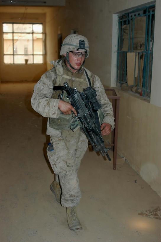 AR RAMADI Iraq (June 17, 2005) - Lance Cpl. David C. "Dotty" Dotson, a squad automatic weapon gunner, with 2nd Squad, 2nd Platoon, Company A, 1st Battalion, 5th Marine Regiment, walks through building searching for threats during a mission in the city here. The 20-year-old from Wilton, Iowa, and his fellow 2nd and 3rd Platoon, Company A warriors' were conducting a search mission when they were called on to provide security for a platoon of Company C Marines who hit an IED. The Marines set up lookouts on rooftops a few hundred yards from the attack seen. They remained in their surveillance positions for more than two hours. Photo by: Cpl. Tom Sloan