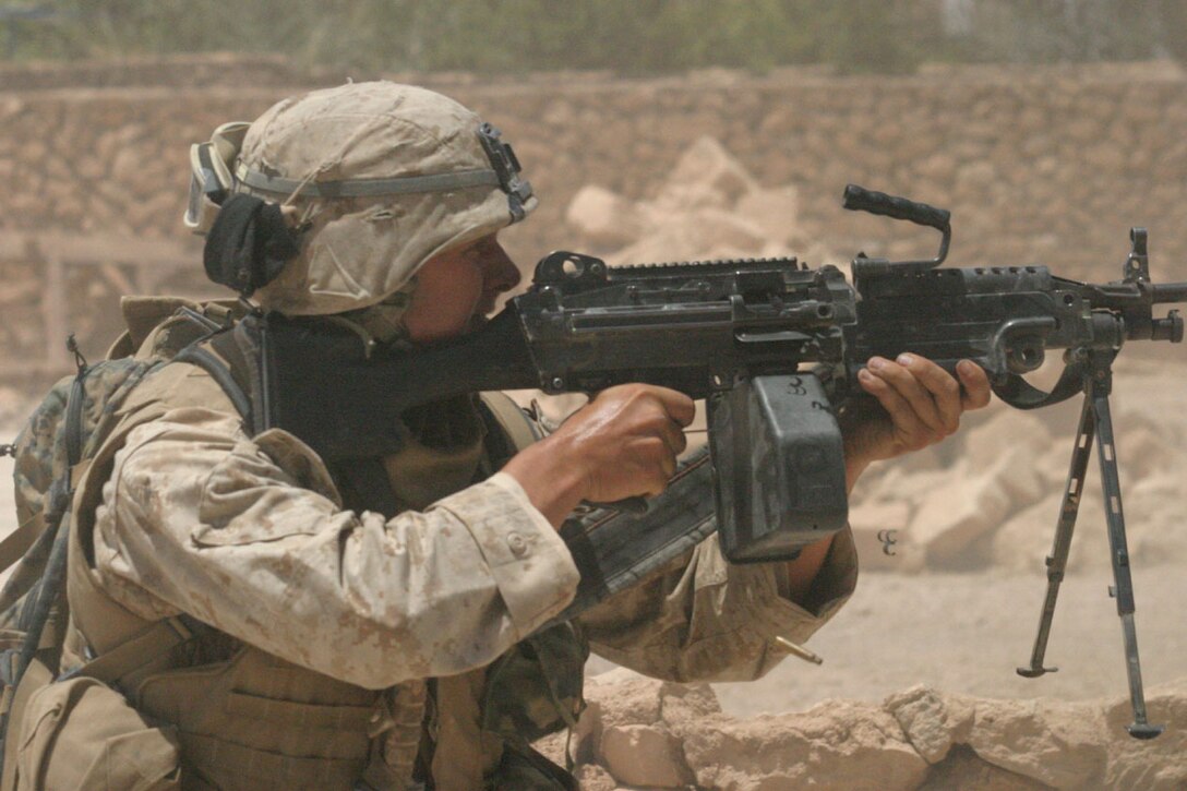 KARABILAH, Iraq- (June 17, 2005)- Pfc. Nathan W. Pesch-Scott, a squad automatic weapon gunner with 3rd Squad, 3rd Platoon, Company K, 3rd Battalion, 2nd Marine Regiment opens fire on a sniper in Karabilah after recieving fire.  Operation Spear is conducted to destroy insurgency leadership strong points.  The Marines of 2d Marine Division conduct counter-insurgency operations with Iraqi Security Forces to isolate and neutralize anti-Iraqi forces, to support the continued development of Iraqi Security Forces, and to support Iraqi reconstruction and democratic elections in order to create a secure environment that enables Iraqi self-reliance and self-governance. (Official USMC photo by Cpl. Neill A. Sevelius (RELEASED)