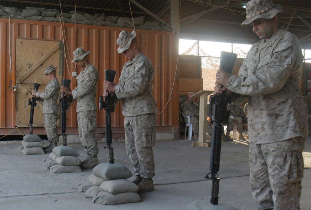 051020-M-2607O-001 - Marines from Company G place the down turned rifle in a pile of sand bags as part of the memorial emblem for the fallen Marines that died on Oct. 6, helping to make Iraq a free country.