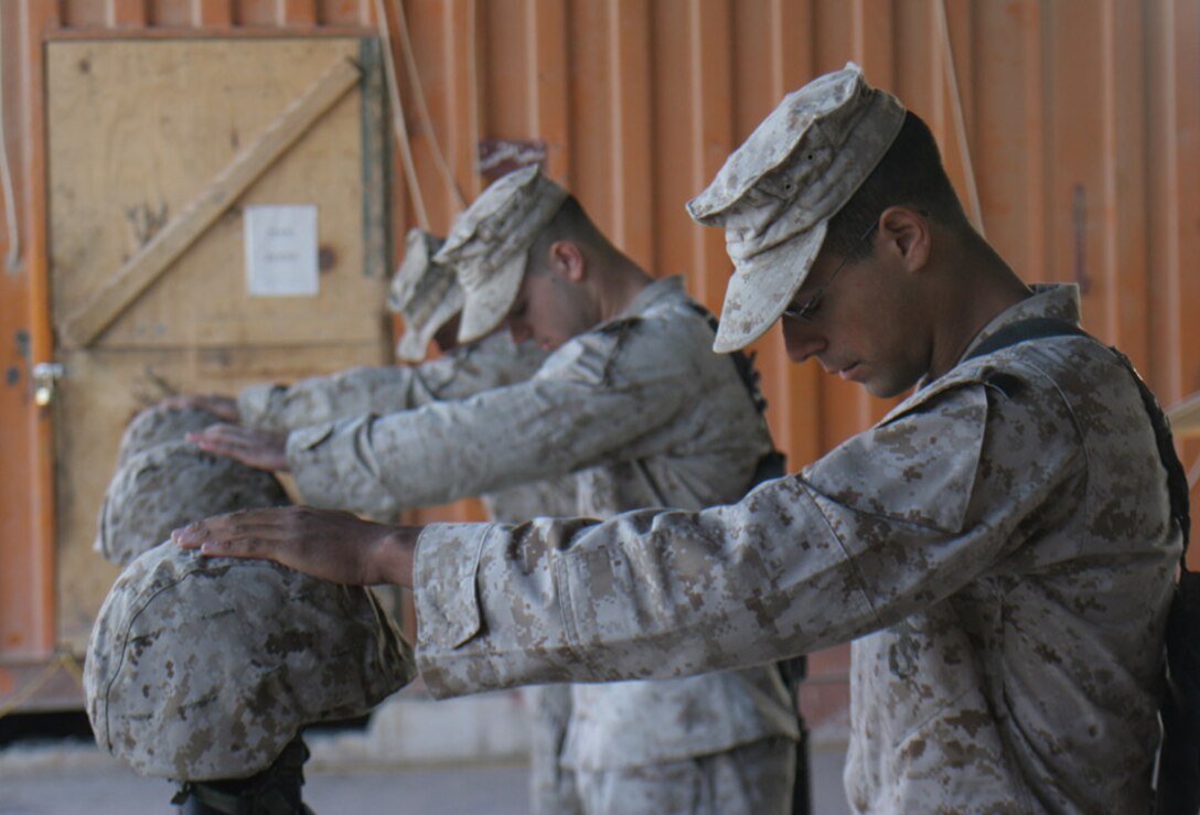 051028-M-2607O-012 - Marines from Weapons Company say their goodbye's to their fallen comrades by placing their hand on the Kevlar of the memorial emblem following the memorial service Oct. 28.