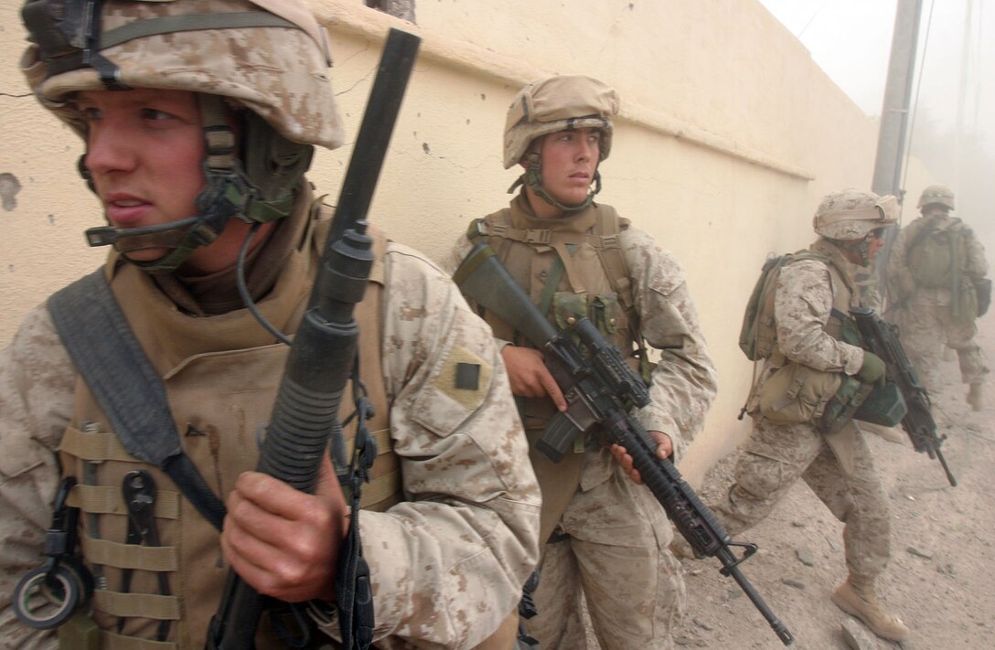 CAMP AL QA'IM, Iraq (Nov. 15, 2005) -- Waynesberg, Pa., native Lance Cpl. Steven L. Phillips stands with his shotgun and Mk-152 Shoulder Mounted Antitank Weapon read to advance if called.  Behind him in support is Albany, N.Y., native Lance Cpl. Paul J. Kolkhorst.  Both Marines are antitank assaultmen and participated in Operation Steel Curtain with Company I, 3rd Battalion, 6th Marine Regiment, Regimental Combat Team - 2.
