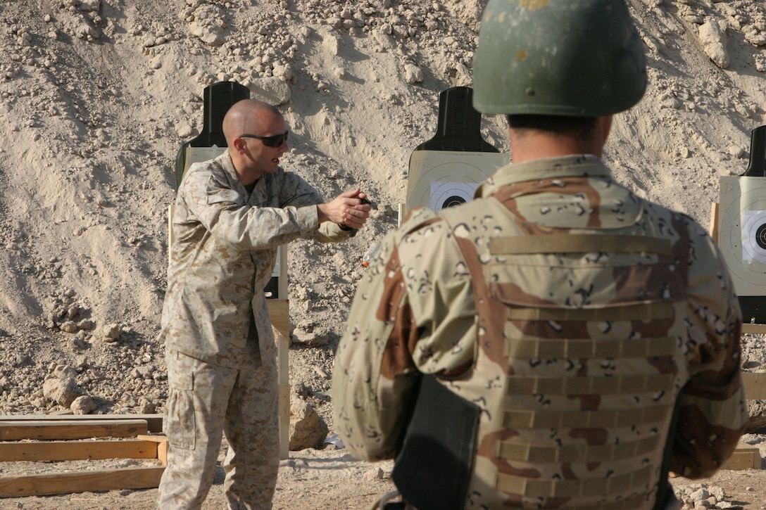 CAMP HABBANIYAH, Iraq - Sergeant Peter K. McKinney, the chief instructor for Personal Security Detail Development course, demonstrates how the aim of a pistol is thrown off by anticipating the discharge of the weapon.