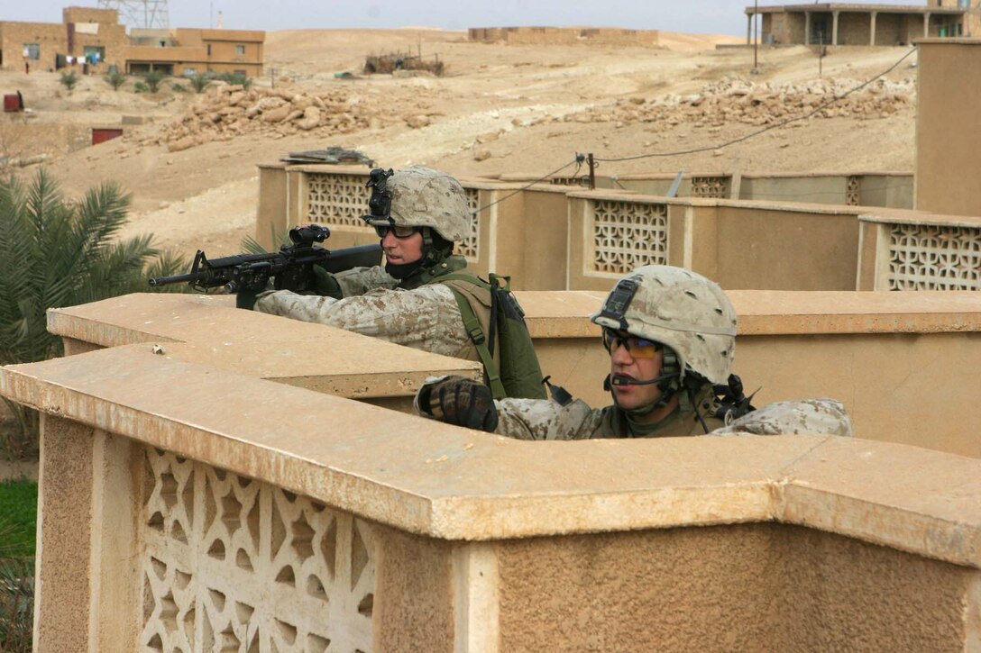 BARWANA, Iraq (Jan. 18, 2006) - (Front to back) Lance Cpl. Sam E. Smithson and Lance Cpl. James Nankervis, both Marines with Company L, 3rd Battalion, 1st Marine Regiment provide watch on a rooftop during Operation Red Bull II Jan. 18. The Marines along with Iraqi Army soldiers cleared houses and searched for weapons caches to rid the Triad area of insurgent operations. (Official Marine Corps photo by Cpl. Adam C. Schnell)