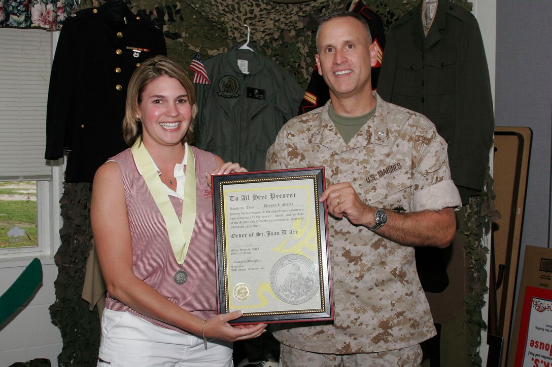 MARINE CORPS BASE CAMP LEJEUNE, N.C. - Lieutenant Colonel Donald C. Morse, the commanding officer of 2nd Tank Battalion, 2nd Marine Division, presented Deanna L. Storer with a certificate of acceptance into the Order of Saint Joan D'Arc here June 9.  Through her tireless and energetic efforts, she has made a dramatic impact on the ability of the battalion to operate efficiently in both garrison and war.