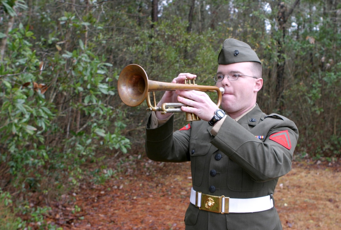 Lance Cpl. Jason A. Martin, the sole bugler for Camp Lejeune's 2d Marine Division, plays Taps during a military ceremony recently.  The 22-year-old Moline, Ill. native plays the ceremonial tune during military honors here to honor fallen warriors.