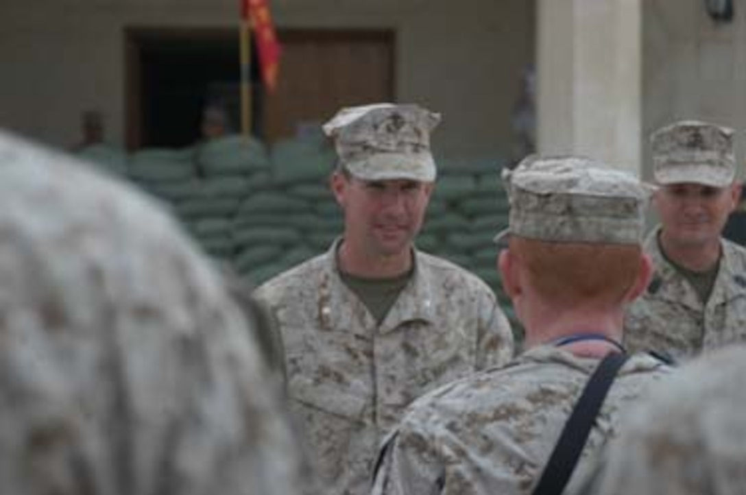 HURRICANE POINT, Ramadi, Iraq - First Battalion, 5th Marine Regiment's 39-year-old commanding officer and Plano, Texas native, Lieutenant Col. Eric M. Smith, smiles at Staff Sgt. Robert D. Oehler, intelligence chief for Headquarters and Service Company, during Oehler's reenlisted ceremony held here March 6, 2005. The 28-year-old Jacksonville, Fla. Native, a Marine with almost a decade of dedicated service to the Corps, swore to devote another four years while in Iraq a second time in support of Operation Iraqi Freedom. Oehler collected a bonus of more than $10,000 that's tax-free because he reenlisted in Iraq, which the Department of Defense designated to be a tax-exclusion zone.                                 (Official United States Marine Corps photo by Cpl. Tom Sloan)