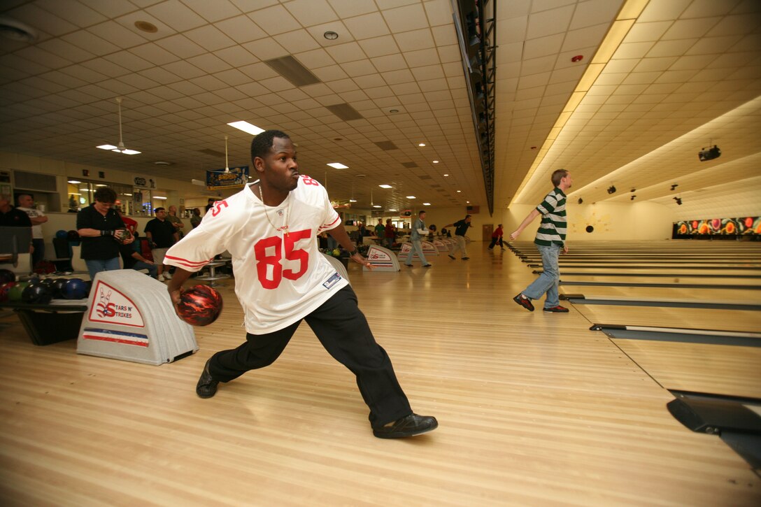 Sgt. Shannon Henley, a field wireman with Marine Wing Communications Squadron 28, takes his shot at a strike during a tournament held in support of Toys for Tots at the Stars and Strikes bowling center, Dec. 4. The annual event brought out 56 civilians and Marines who each donated a toy to participate in the tournament.