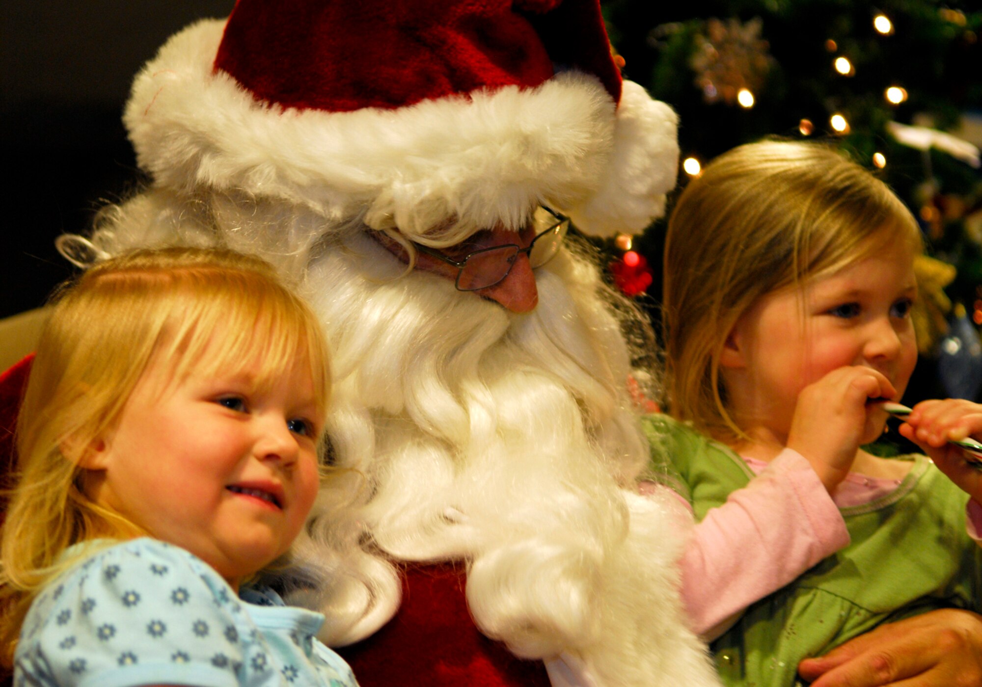 VANDENBERG AIR FORCE BASE, Calif. -- Children of Vandenberg Airmen smile while having their photograph taken with Santa Claus at Building 11777 for the Holiday Tree Lighting Ceremony on Thursday, Dec. 3, 2009. After the holiday tree was lit, everyone gathered inside to see Santa and put in their Christmas wish lists. (U.S. Air Force photo/Senior Airman Ashley Reed)