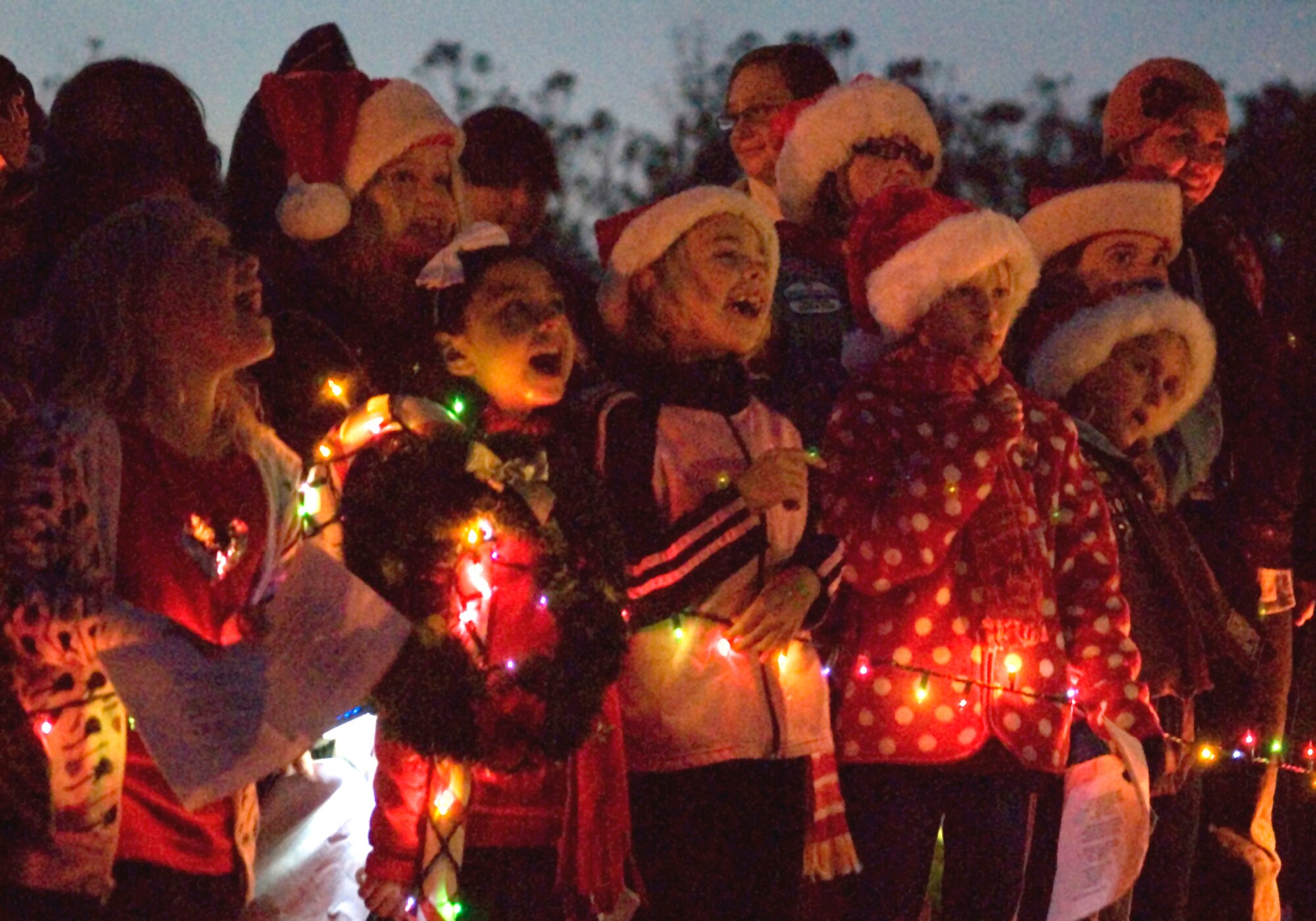 VANDENBERG AIR FORCE BASE, Calif. -- Reminding people that Santa Claus is coming to town, Girl Scouts from Vandenberg sing Christmas carols during the Holiday Tree Lighting Ceremony here on Thursday, Dec. 3, 2009, outside of Building 11777. Members of the Vandenberg Girl Scouts sang multiple songs throughout the ceremony to usher in the holiday season. (U.S. Air Force photo/Senior Airman Ashley Reed)