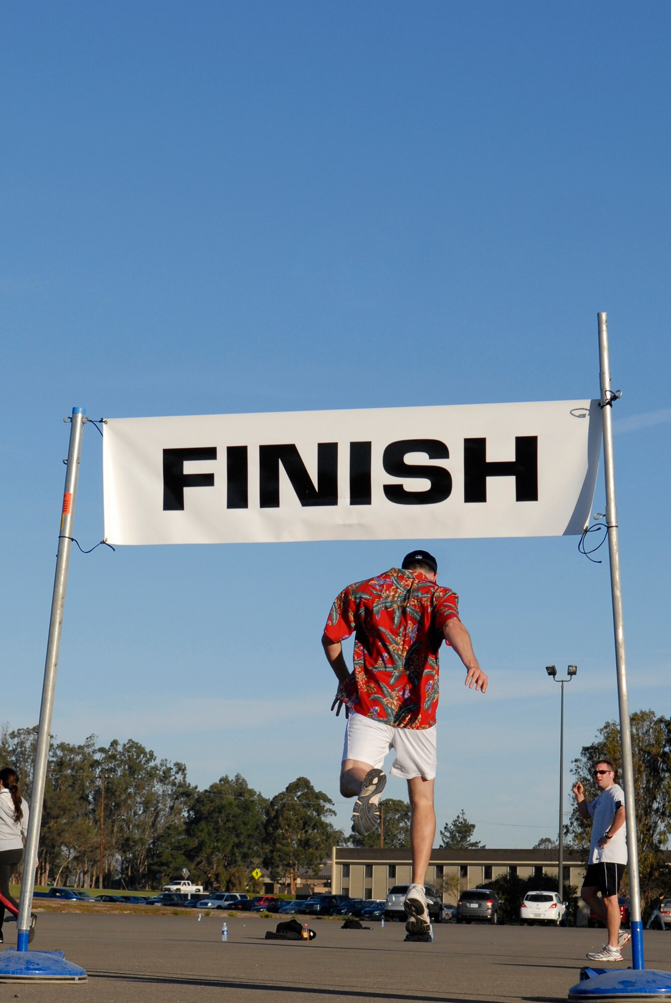 VANDENBERG AIR FORCE BASE, Calif. -- An Airman leaps through the finish line of a 10K run during Wingman Day here Friday, Dec. 4, 2009.  The day's events were meant to promote teamwork and taking care of fellow Wingmen.  (U.S. Air Force photo/Senior Airman Andrew Satran)