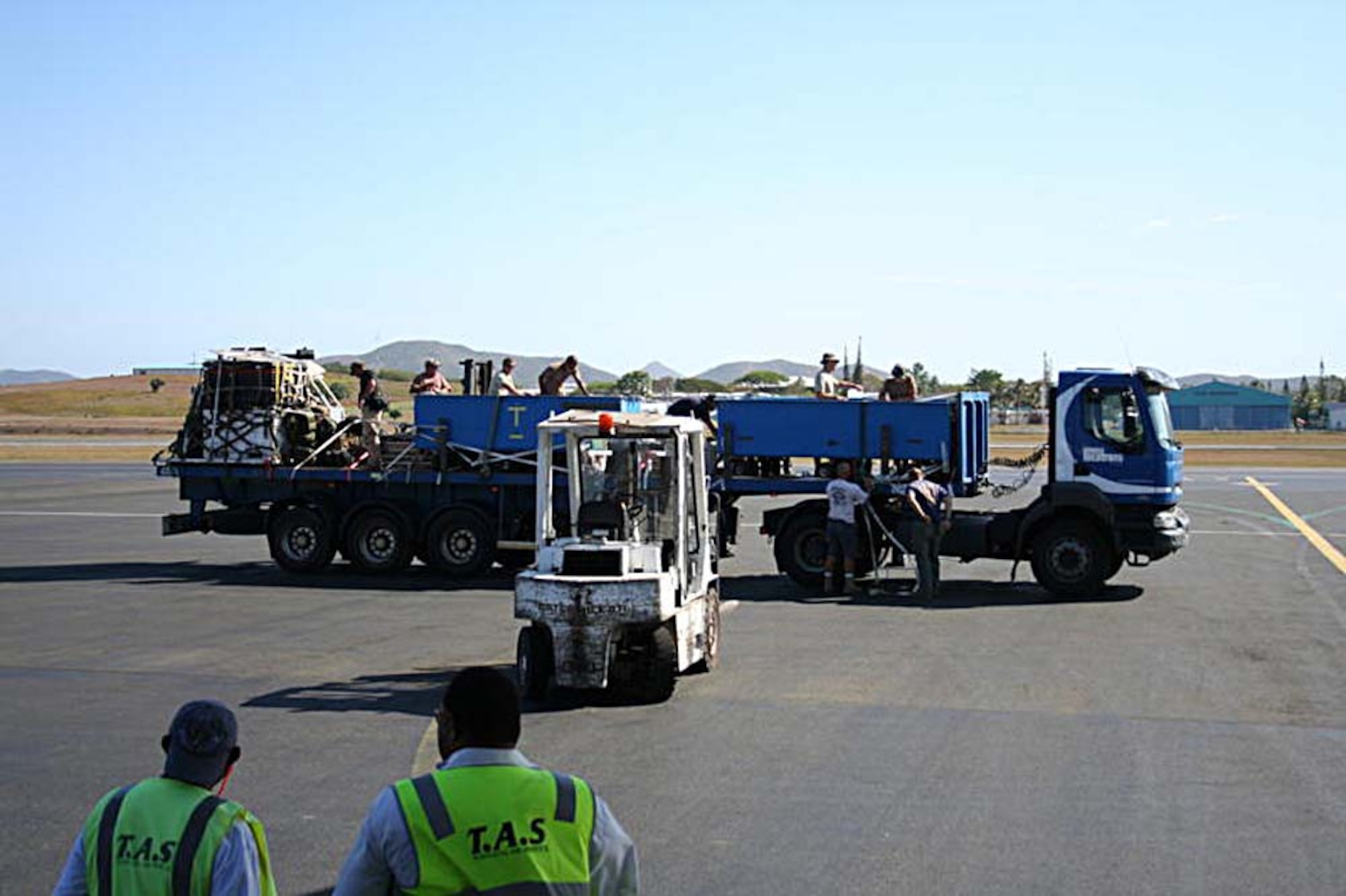 Workers in New Caledonia unload the dolphins from a flatbed truck in preparation for loading on a C-17 flown by the 313th Airlift Squadron, McChord Air Force Base, Wash. The dolphins, part of the U. S. Navy Marine Mammals program, San Diego, Calif., were returning home. The dolphins were in Noumea, New Caledonia, for Lagoon MINEX 2009. (U.S. Air Force photo/Tech. Sgt. Heather Normand)
