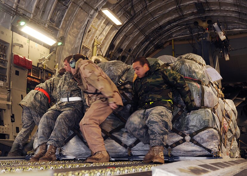 MOODY AIR FORCE BASE, Ga. -- Tech. Sgt. Jerry Good and Staff Sgt. David Garman, 23rd Logistics Readiness Squadron air transporters, and Senior Airman Nicholas Hollman, 4th Airlift Squadron loadmaster from McChord Air Force Base, Wash., push a pallet onto the back of a C-17 Globemaster III here Dec. 2. (U.S. Air Force photo by Airman 1st Class Joshua Green)