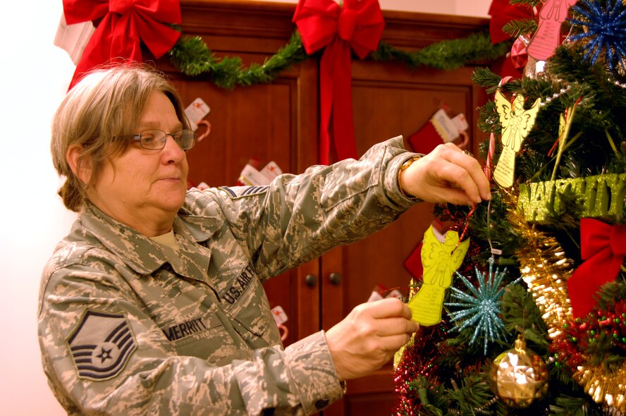 MOODY AIR FORCE BASE, Ga. -- Master Sgt.  Margaret Merritt, 23rd Force Support Squadron Airman and Family Readiness Center readiness NCO, picks an ornament from the Angel Tree at the A&FRC here Dec. 2. The Angel Tree project improves the holiday season for military families by providing the children of Moody members with gifts. (U.S. Air Force photo by Airman 1st Class Brigitte Brantley)