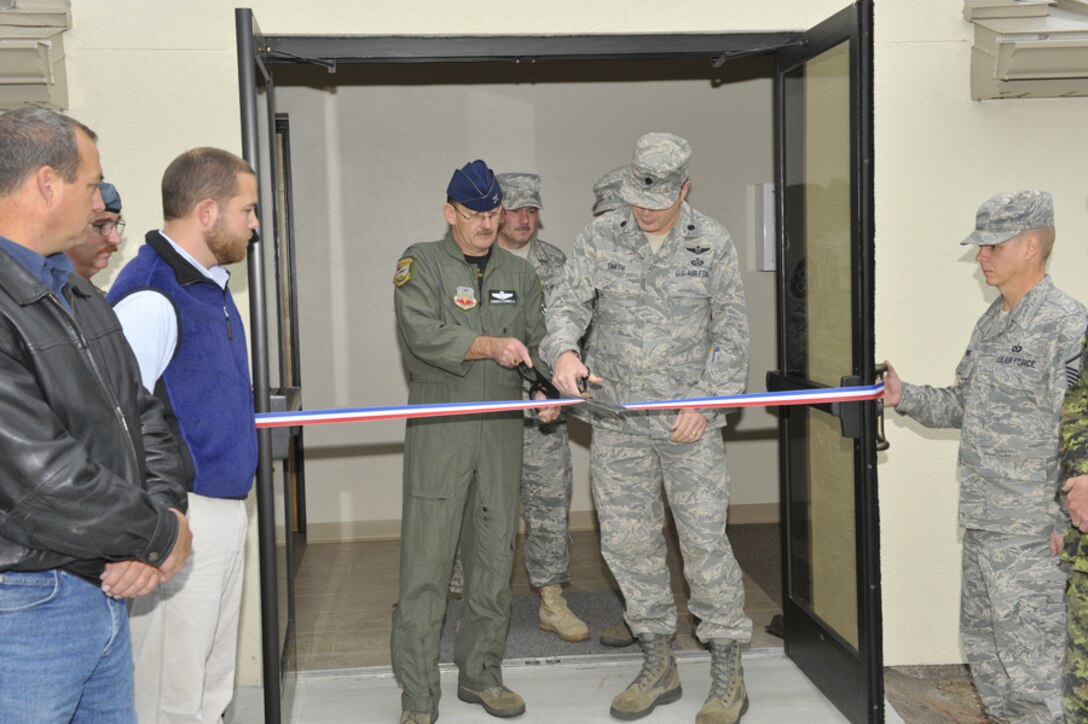 Colonel Domenick Eanniello, 1st Air Force vice commander, left, and Lt. Col. David Smith, commander of Tyndall’s 702nd Computer Systems Squadron-System Support Facility, cut a ribbon that marks the official opening of a newly renovated building that houses the air defense computer support organization. (U.S. Air Force photo by Jonathan Gibson)