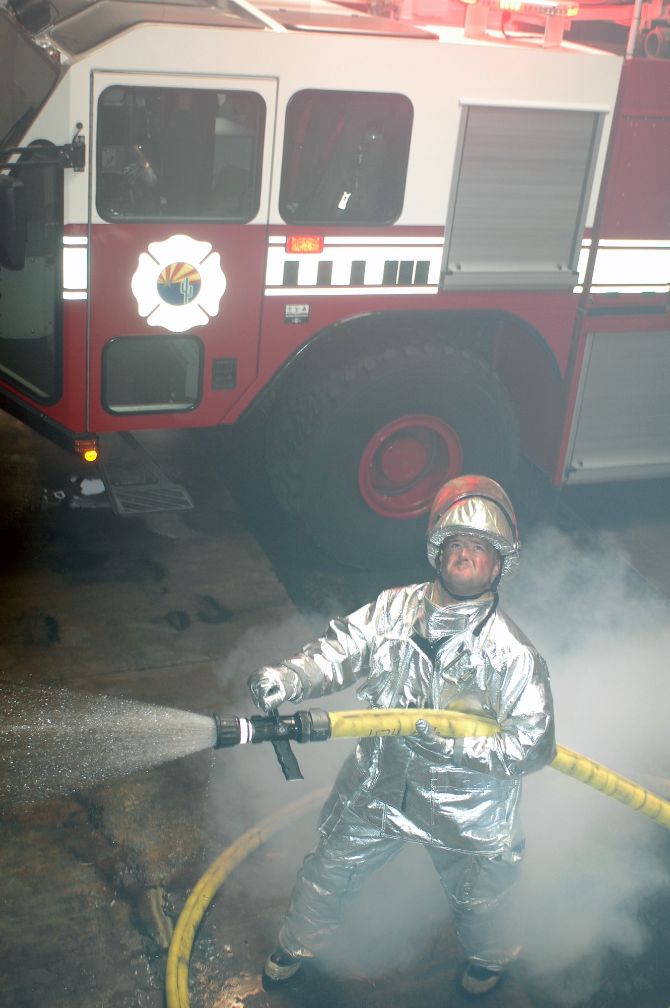 Staff Sgt. David Arneson simulates putting out a fire in the base fire station Dec. 2. The demonstration was photographed for use in brochures intended to attract recruits with prior active duty military experience. (Air Force photo by Maj. Gabe Johnson)