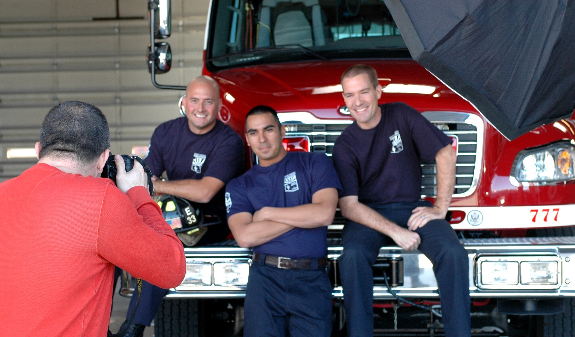 ANG Creative Team photographer Rob Trubia takes photographs of Staff Sgt. David Arneson, Senior Airman Joe De Vos and Master Sgt. Jeff Schultz in the base fire station Dec. 2. The photos will be used in brochures intended to attract recruits with prior active duty military experience. (Air Force photo by Maj. Gabe Johnson)