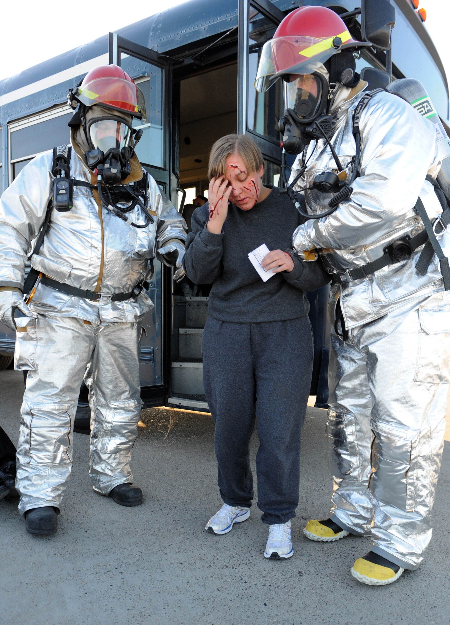 MOUNTAIN HOME AIR FORCE BASE, Idaho -- Firefighters from the 366th Civil Engineer Squadron fire protection flight help Airman Kandice Whitt, 726th Air Control Squadron aerospace ground equipment management, off a bus as she simulates being injured from a simulated C-17 Globemaster crash during an emergency management exercise Dec. 2. The 366th Fighter Wing conducts exercises to prepare first responders and wing personnel for a variety of possible emergencies and accidents. (U.S. Air Force photo by Airman 1st Class Debbie Lockhart)