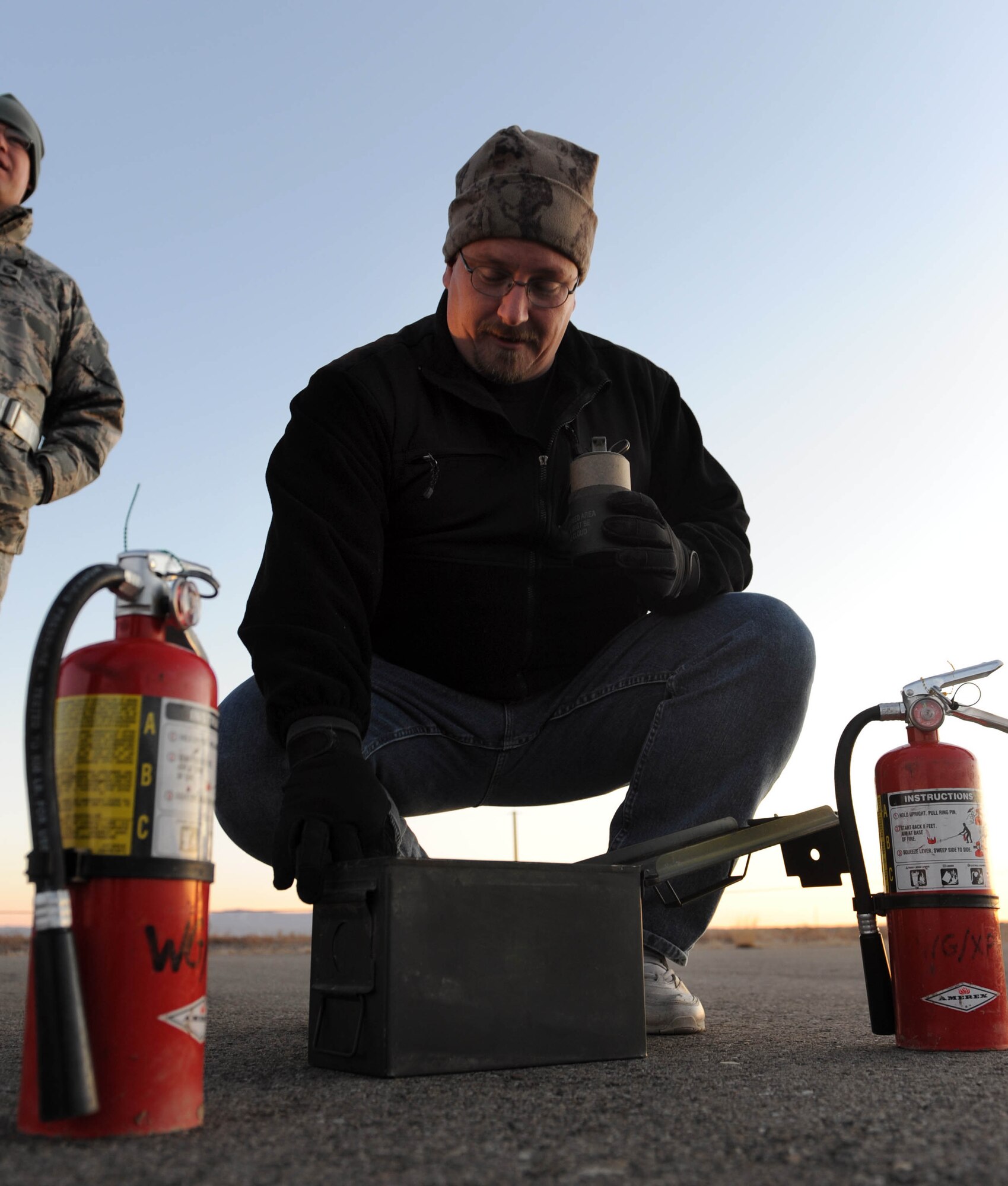 MOUNTAIN HOME AIR FORCE BASE, Idaho -- Stephen Spealman, 366th Fighter Wing plans and programs exercise coordinator, prepares smoke grenades to simulate a C-17 Globemaster crash during an emergency management exercise Dec. 2. The 366th Fighter Wing conducts exercises to prepare first responders and wing personnel for a variety of possible emergencies and accidents. (U.S. Air Force photo by Airman 1st Class Debbie Lockhart)