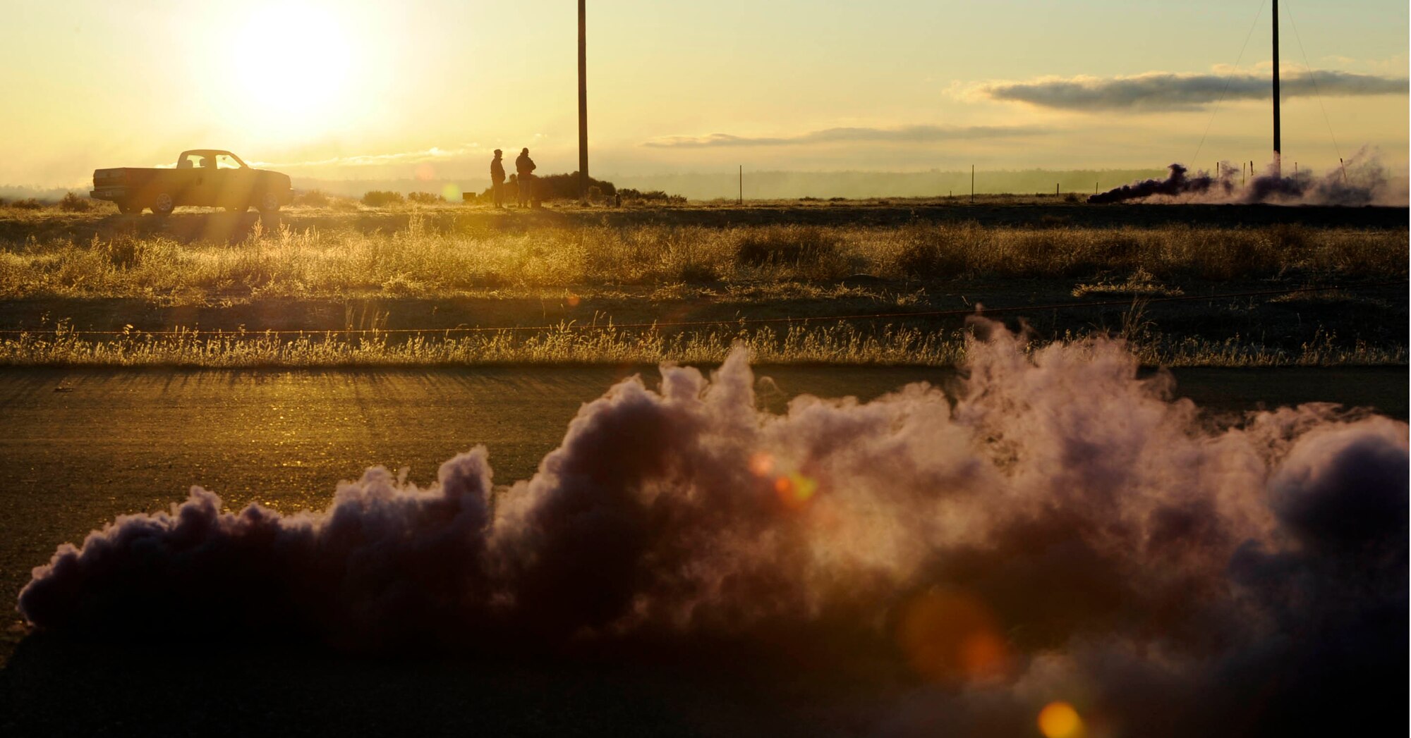 MOUNTAIN HOME AIR FORCE BASE, Idaho -- Tech. Sgts. Ernesto Bolanos and Jeffrey Tibbitts, 366th Maintenance Group quality assurance inspectors, watch smoke grenades, which simulated a C-17 Globemaster crash during an emergency management exercise Dec. 2. The 366th Fighter Wing conducts exercises to prepare first responders and wing personnel for a variety of possible emergencies and accidents. (U.S. Air Force photo by Airman 1st Class Debbie Lockhart)