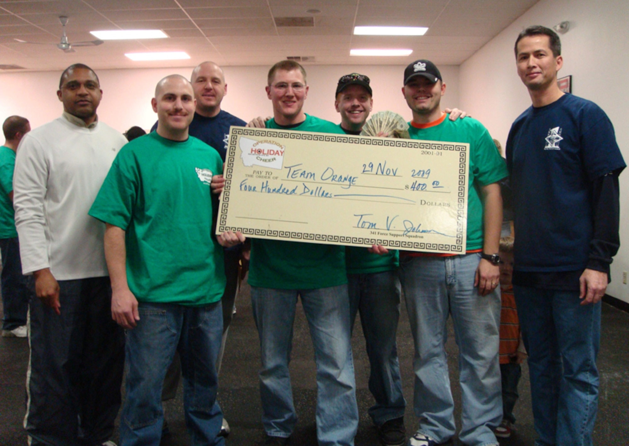 The third of five Operation Holiday Cheer events took place Nov. 25-26 where nine teams hunted for treasures and other incidental items during a scavenger hunt. Pictured are first place winners, Team Orange, and members of the first sergeants council, who is sponsoring the five-event competition along with the 341st Force Support Squadron. (U.S. Air Force courtesy photo)