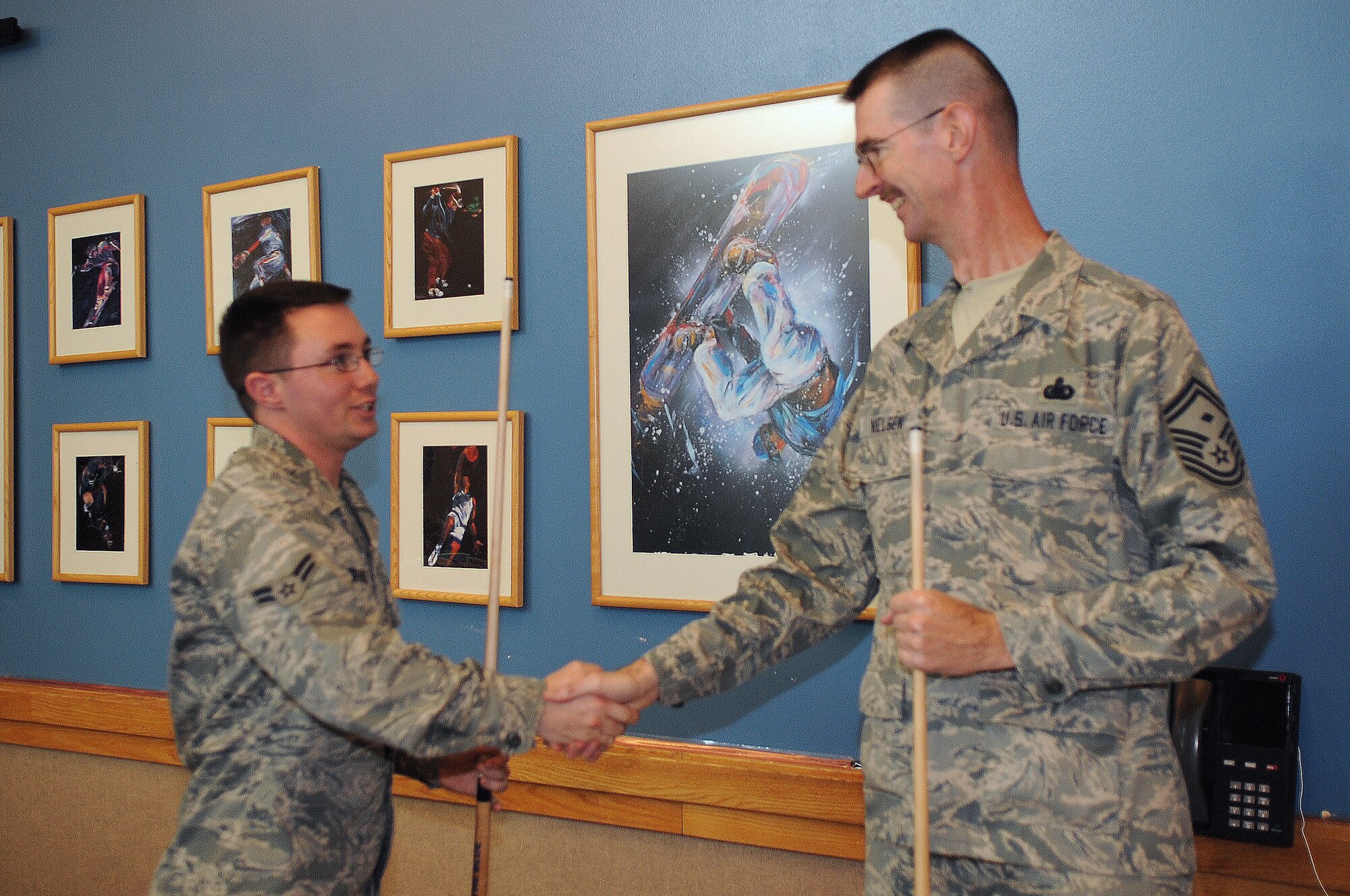 BUCKLEY AIR FORCE BASE, Colo.-- Senior Master Sgt. Ernest Nielsen and Airman 1st Class James Crawley shake hands after a game of pool Nov 25. Buckley's 5/6 Council hosted this year's Thanksgiving dinner at the dorms. ( U.S. Air Force photo by Airman 1st Class Marcy Glass )