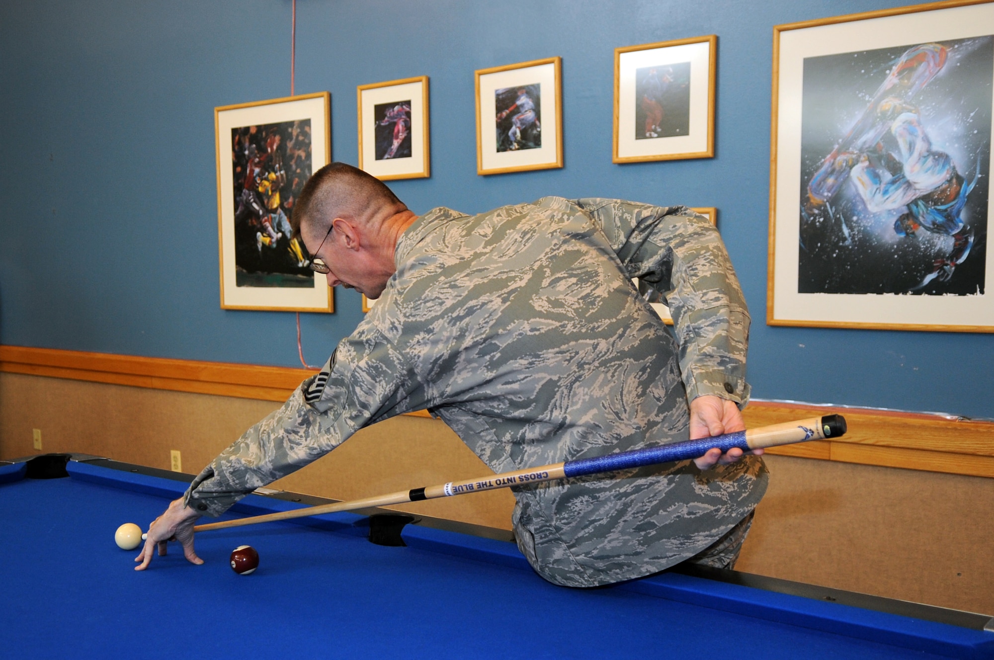 BUCKLEY AIR FORCE BASE, Colo.-- Senior Master Sgt. Ernest Nielsen, 460th Space Communications Squadron first sergeant, plays a game of pool Nov 25 with Airmen living in the dorms. Sergeant Nielsen voluntered for the Thanksgiving Day Dorm Dinner. ( U.S. Air Force photo by Airman 1st Class Marcy Glass )