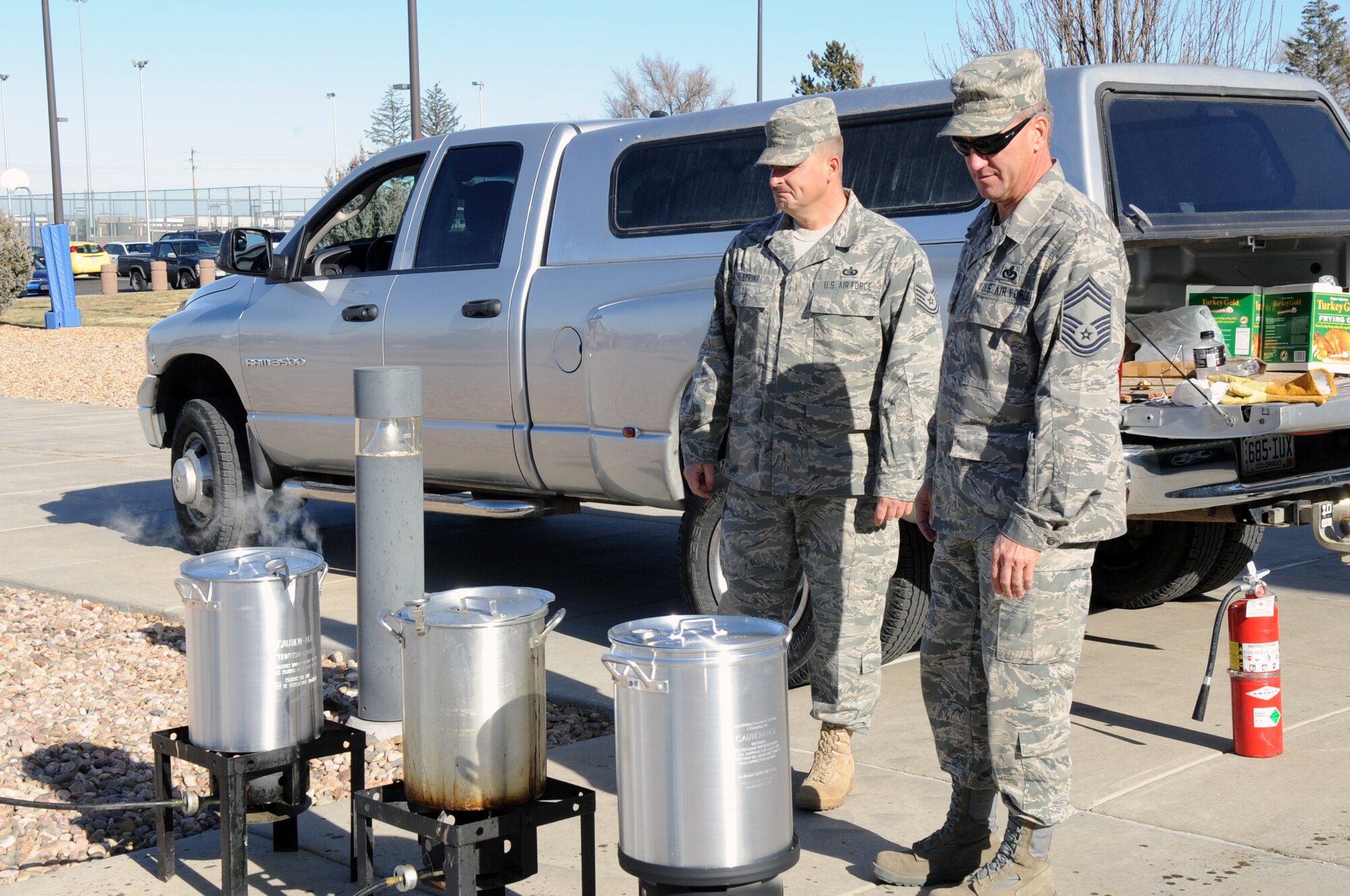 BUCKLEY AIR FORCE BASE, Colo. -- U.S. Air Force Chief Master Sgt. Robert Williams and Tech Sgt. Robert Spring cook turkeys Nov. 25. Chief Williams and Sergeant Spring volunteered for the Thanksgiving Day Dorm Dinner. (U.S. Air Force photo by Airman 1st Class Marcy Glass)
