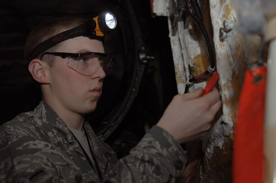 Airman Mattox Davis, 509th Maintenance Squadron Aerospace Propulsion Apprentice, removes fastblock, a flame resistant coating,  so the panel can be removed to access the damaged tail pipe.  (U.S. Air Force photo by Senior Airman Jessica Mae Snow) (Released)