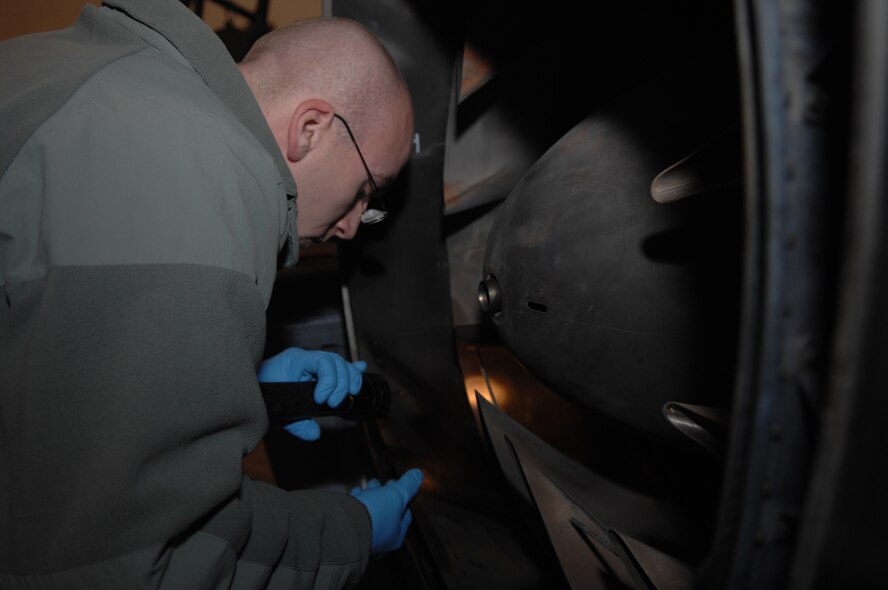 Staff Sgt. Jason Chesonis, a Aerospace Propulsion Craftsman, 509th Maintenance Squadron, inspects the exhaust on a B-2 engine.  The engine must be inspected after removal and before installation.  The engine was removed to access a damaged tail pipe. (U.S. Air Force photo by Senior Airman Jessica Mae Snow) (Released)