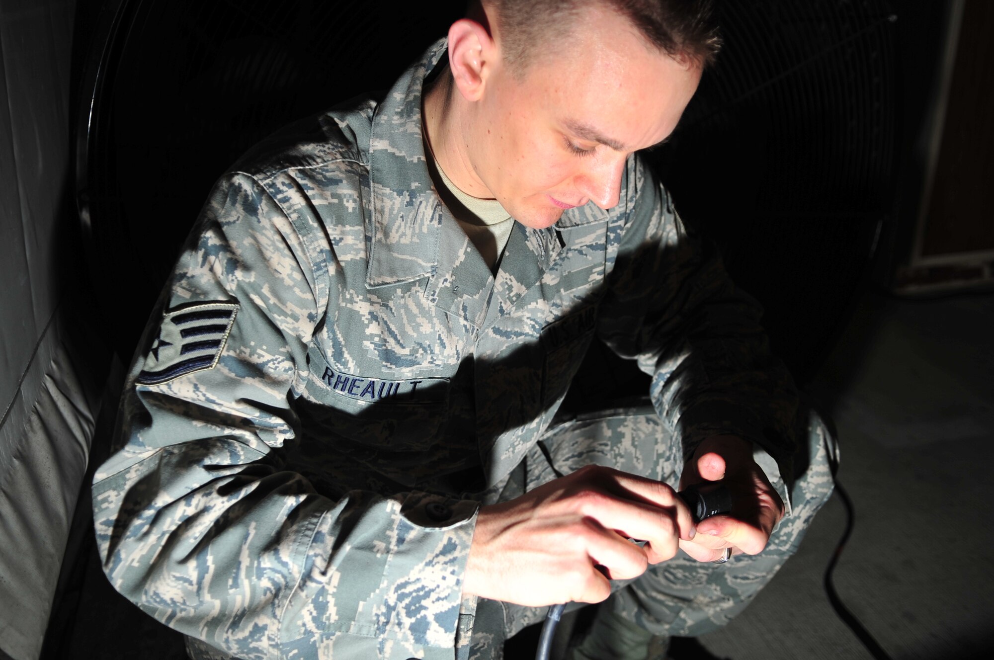 Staff Sgt. Jesse Rheault, 4th Communications Squadron ground radio technician, connects two cables for the giant voice system in Base X on Seymour Johnson Air Force Base, N.C., Dec. 3, 2009. The giant voice system will provide Airmen participating in the Phase II operational readiness exercise with up-to-date alarm conditions and protective posture levels. Sergeant Rheault hails from Fargo, N.D. (U.S. Air Force photo/Airman 1st Class Rae Perry)