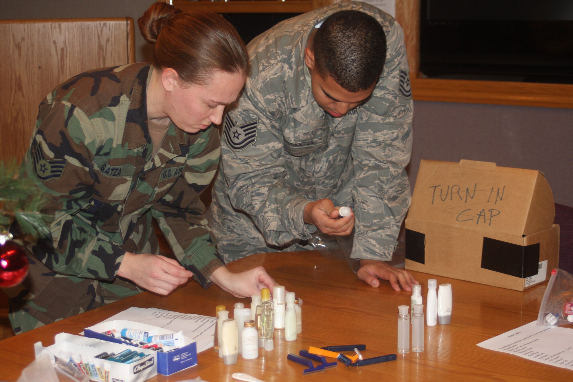 WRIGHT-PATTERSON AIR FORCE BASE, Ohio – Staff Sgt. Chris Gatza, 445th Maintenance Operations Flight, and Tech. Sgt. Ivan Delossantos, 445th Maintenance Operations Flight, inventory shampoo and body wash that will be used with other items to fill bags with items that will be given to residents of the Veterans Affairs Medical Center, Dayton, Ohio, Dec. 5.  Volunteers from the 445th Maintenance Group spent the afternoon filling more than 100 bags with items, such as soap, shampoo, lip balm and combs. Bags were built for both men and women so gender specific items could be included.  (U. S. Air Force photo/Stacy Vaughn)