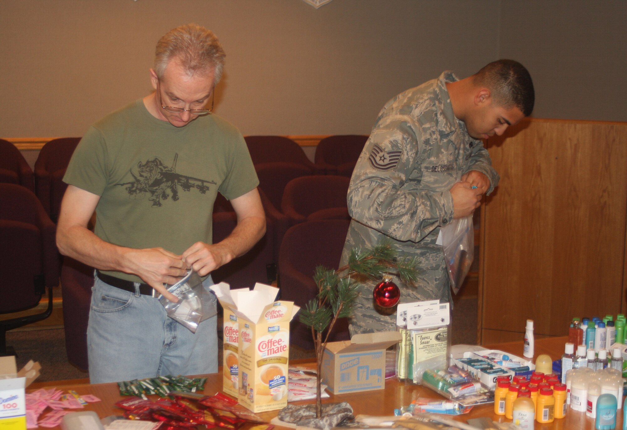 WRIGHT-PATTERSON AIR FORCE BASE, Ohio –Master Sgt. John Guillaum, 445th Maintenance Group, quality assurance, and Tech. Sgt. Ivan Delossantos, 445th Maintenance Operations Flight, fill bags with items that will be given to residents of the Veterans Affairs Medical Center, Dayton, Ohio, Dec. 5.  Volunteers from the 445th Maintenance Group spent the afternoon filling more than 100 bags with items, such as soap, shampoo, lip balm and combs. Bags were built for both men and women so gender specific items could be included.  (U. S. Air Force photo/Stacy Vaughn)