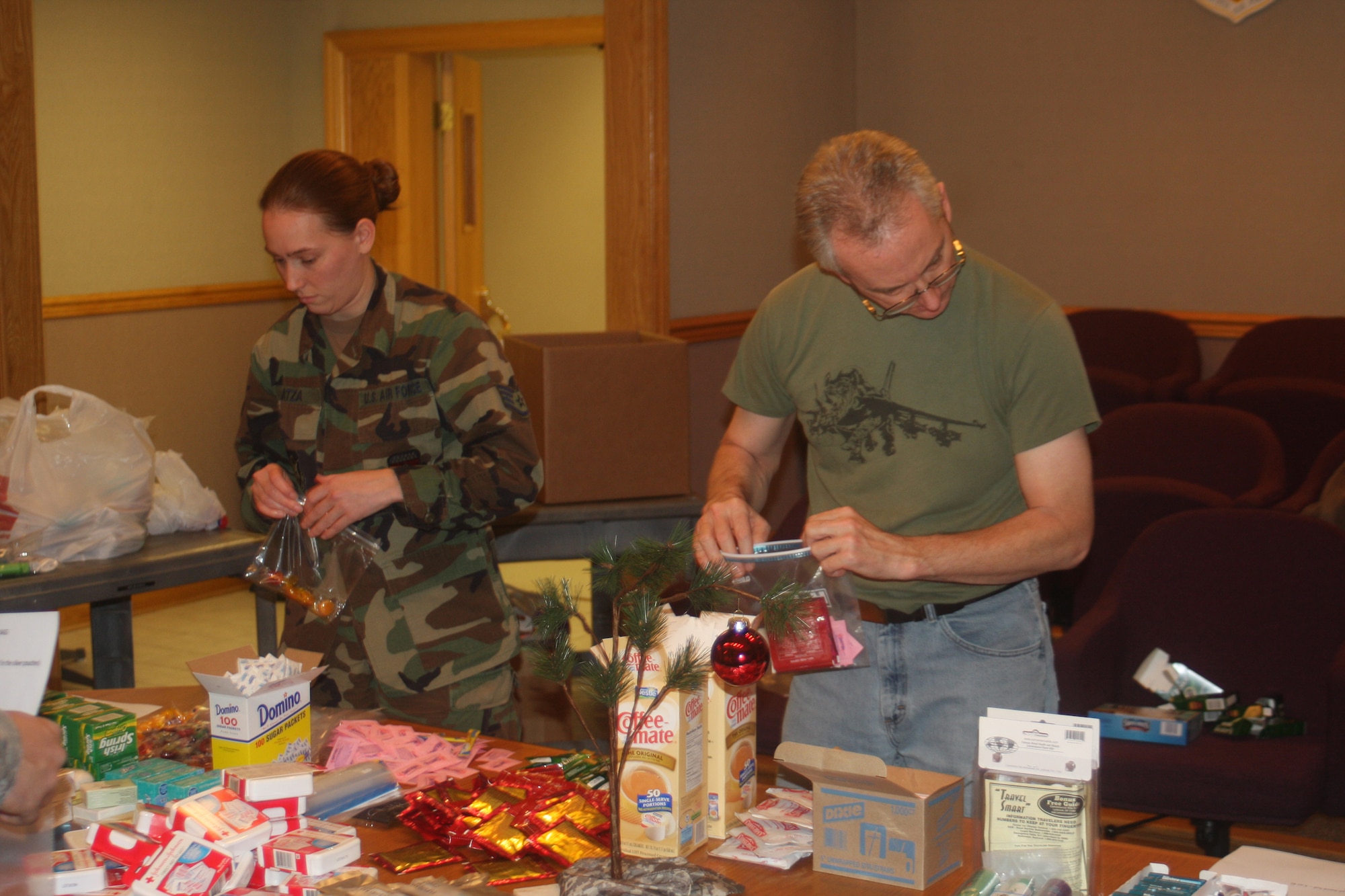 WRIGHT-PATTERSON AIR FORCE BASE, Ohio – Staff Sgt. Chris Gatza, 445th Maintenance Operations Flight, and Master Sgt. John Guillaum, 445th Maintenance Group, quality assurance, fill bags with items that will be given to residents of the Veterans Affairs Medical Center, Dayton, Ohio, Dec. 5.  Volunteers from the 445th Maintenance Group spent the afternoon filling more than 100 bags with items, such as soap, shampoo, lip balm and combs. Bags were built for both men and women so gender specific items could be included.  (U. S. Air Force photo/Stacy Vaughn)