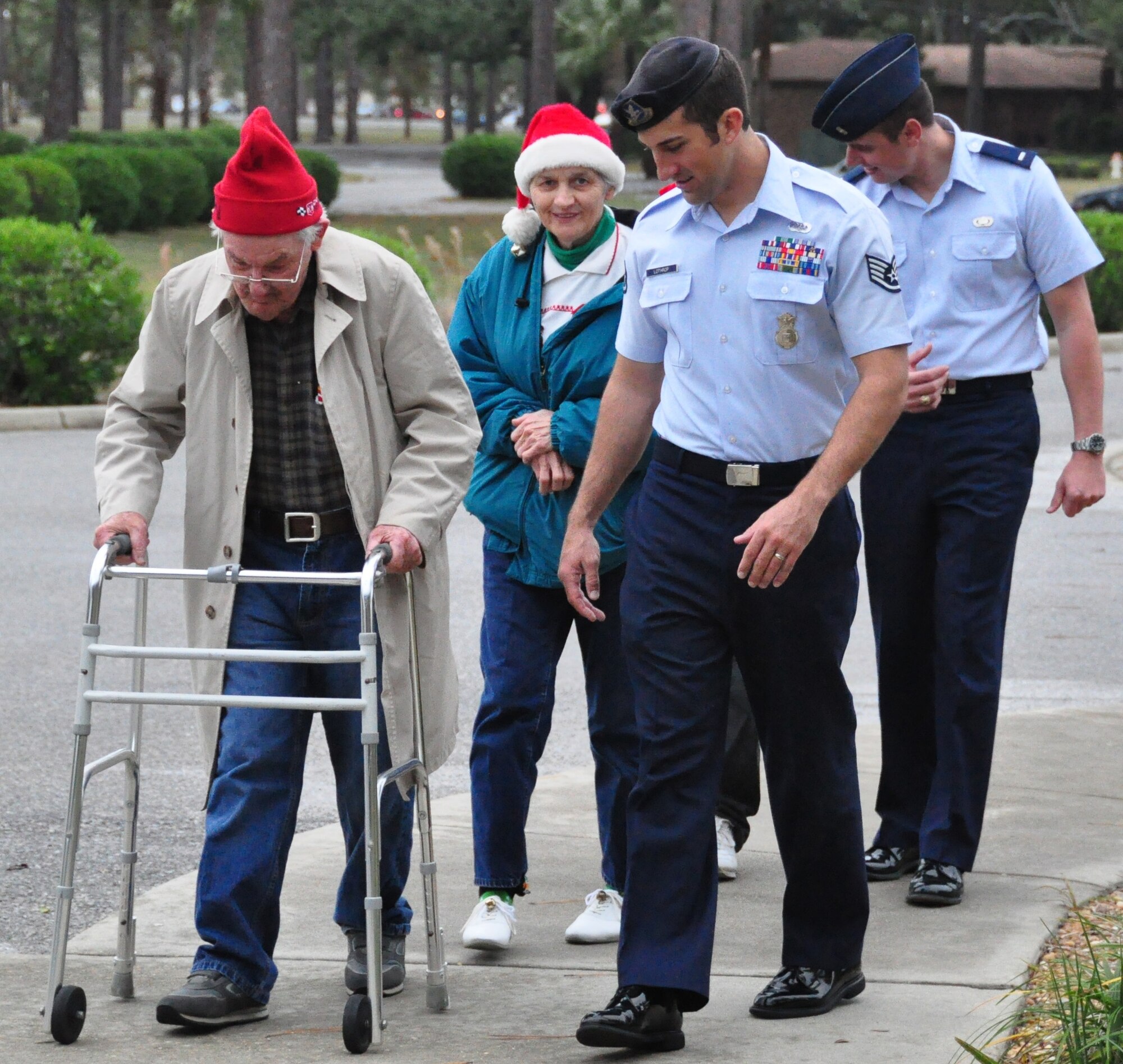 Airmen escort guests into the 23rd annual Golden Age Holiday Party Dec. 2 at the Heritage Club. (U.S. Air Force photo by Airman 1st Class Rachelle Elsea)
