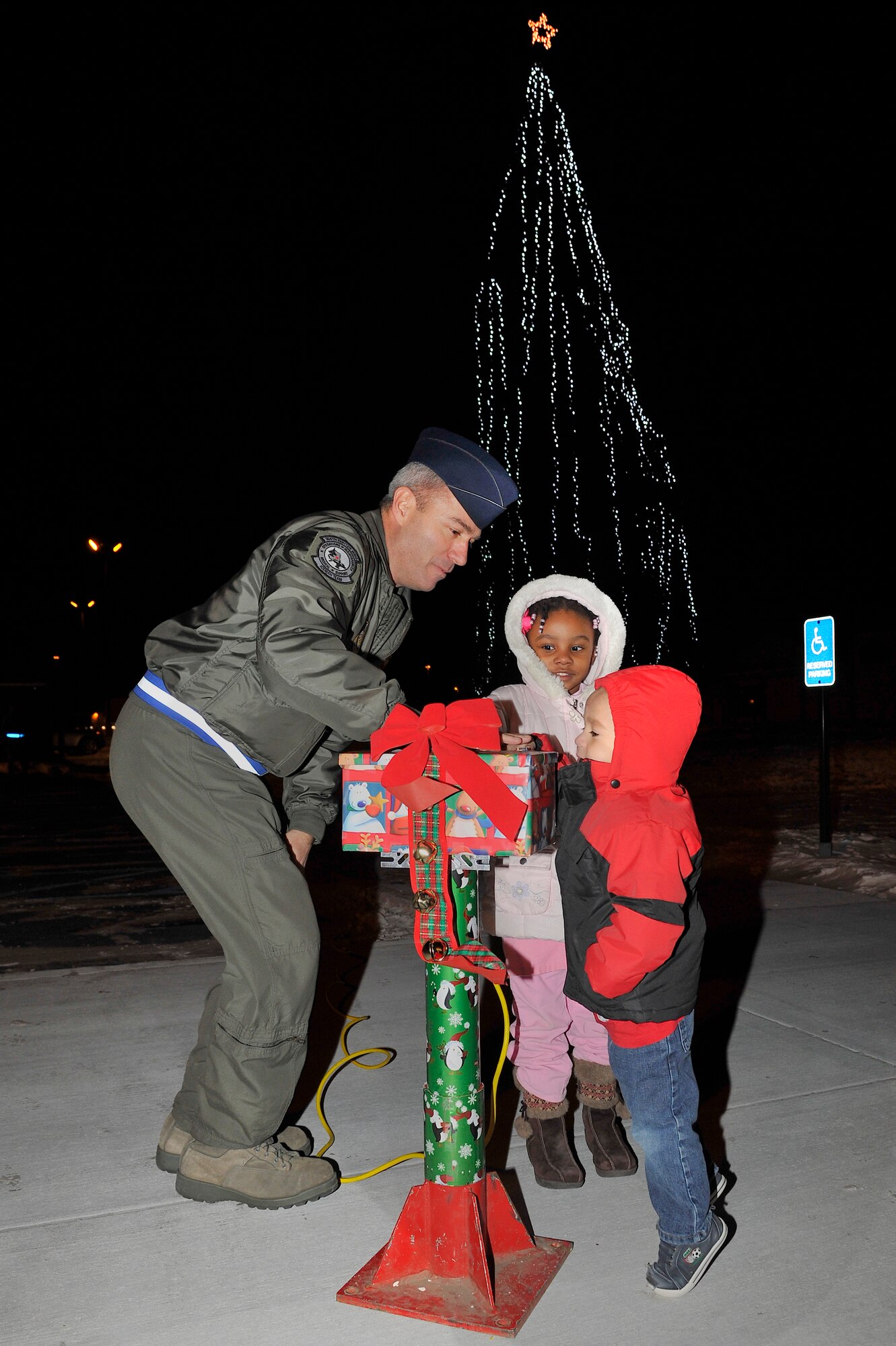 Col. Michael Jordan and two Eielson youth light the base Christmas tree outside of the chapel Dec. 1, 2009, Eielson Air Force Base, Alaska. Colonel Jordan is the vice wing commander of the 354th Fighter Wing. (U.S. Air Force photo/Staff Sgt. Christopher Boitz)