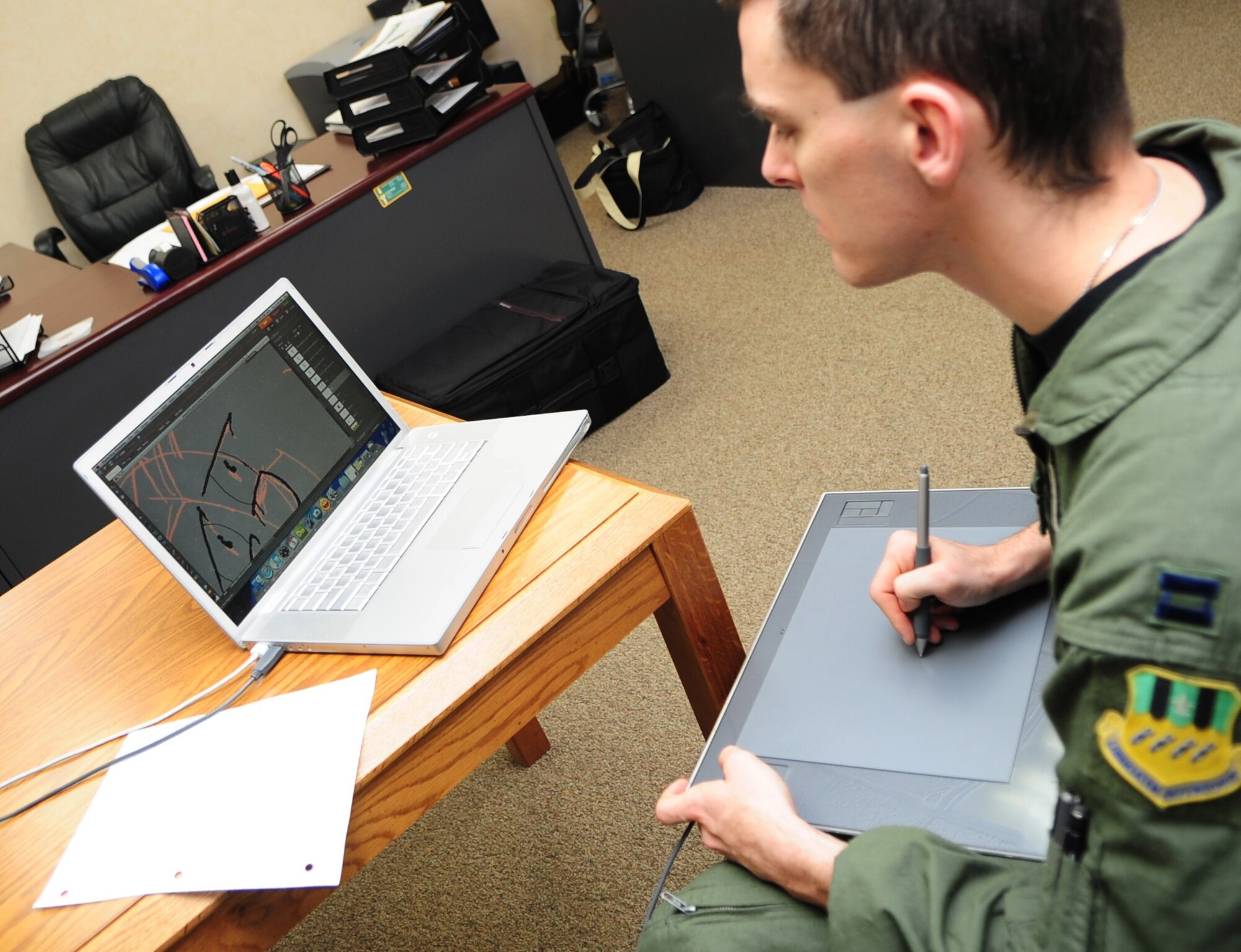 Capt. Timothy "Beetle" Tryon sketches the newest panel in his Air Force comic "Crew Dogs." Captain Tryon has been drawing comics since his freshman year of college. In 2006, he started creating Air Force-related comics based on his experiences. (U.S. Air Force photo by Senior Airman Megan M. Tracy)