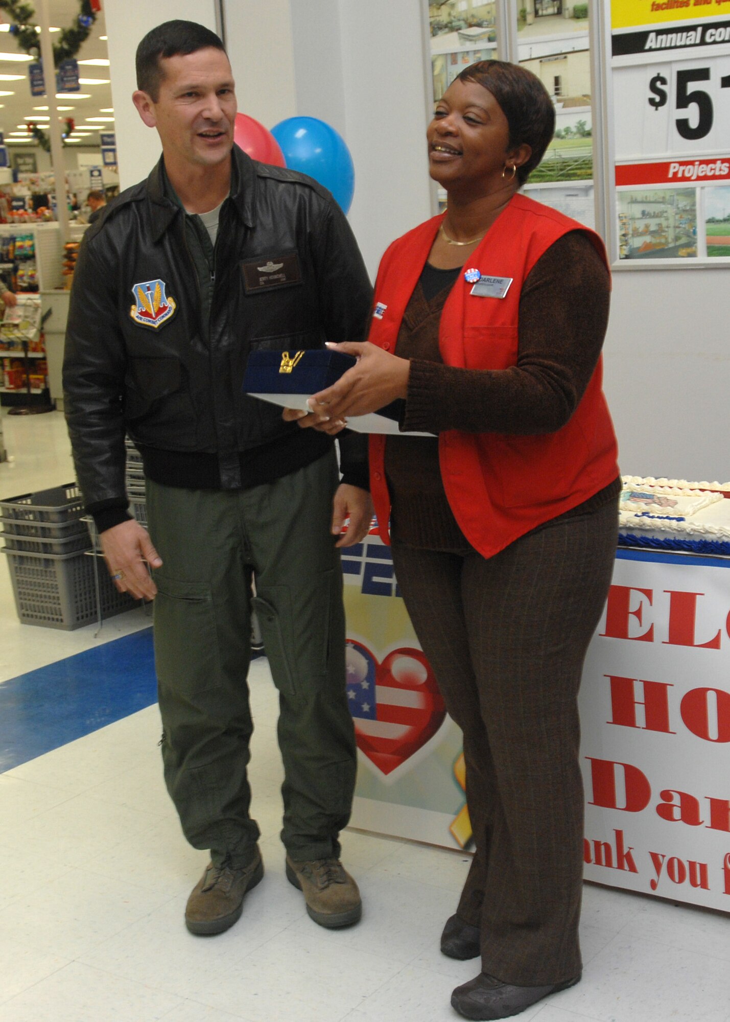 Col. Gerald Hounchell, 2d Bomb Wing vice commander, presented AAFES employee Darlene Downing a plaque during her welcome home ceremony at the Barksdale base exchange Dec. 1.  Ms. Downing served a 14-month deployment in Afghanistan and is preparing to deploy again in May 2010.  (U.S. Air Force photo by Staff Sgt. Sarah E. Stegman)