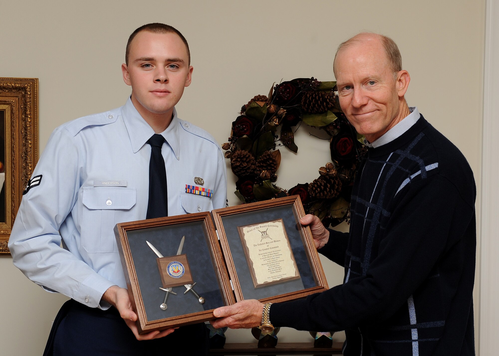 UNION HALL, Va. – Airman 1st Class Ethan Anderson, 1st Logistics Readiness Squadron, presents  retired Gen. John D. W. Corley, former commander for Air Combat Command, an invitation to his Order of the Sword induction ceremony Dec. 3 in General Corley’s home. The Order of the Sword induction ceremony, which is the highest honor enlisted men and women can bestow upon an officer, is Jan. 13. (U.S. Air Force photo/Airman Rebecca Montez)