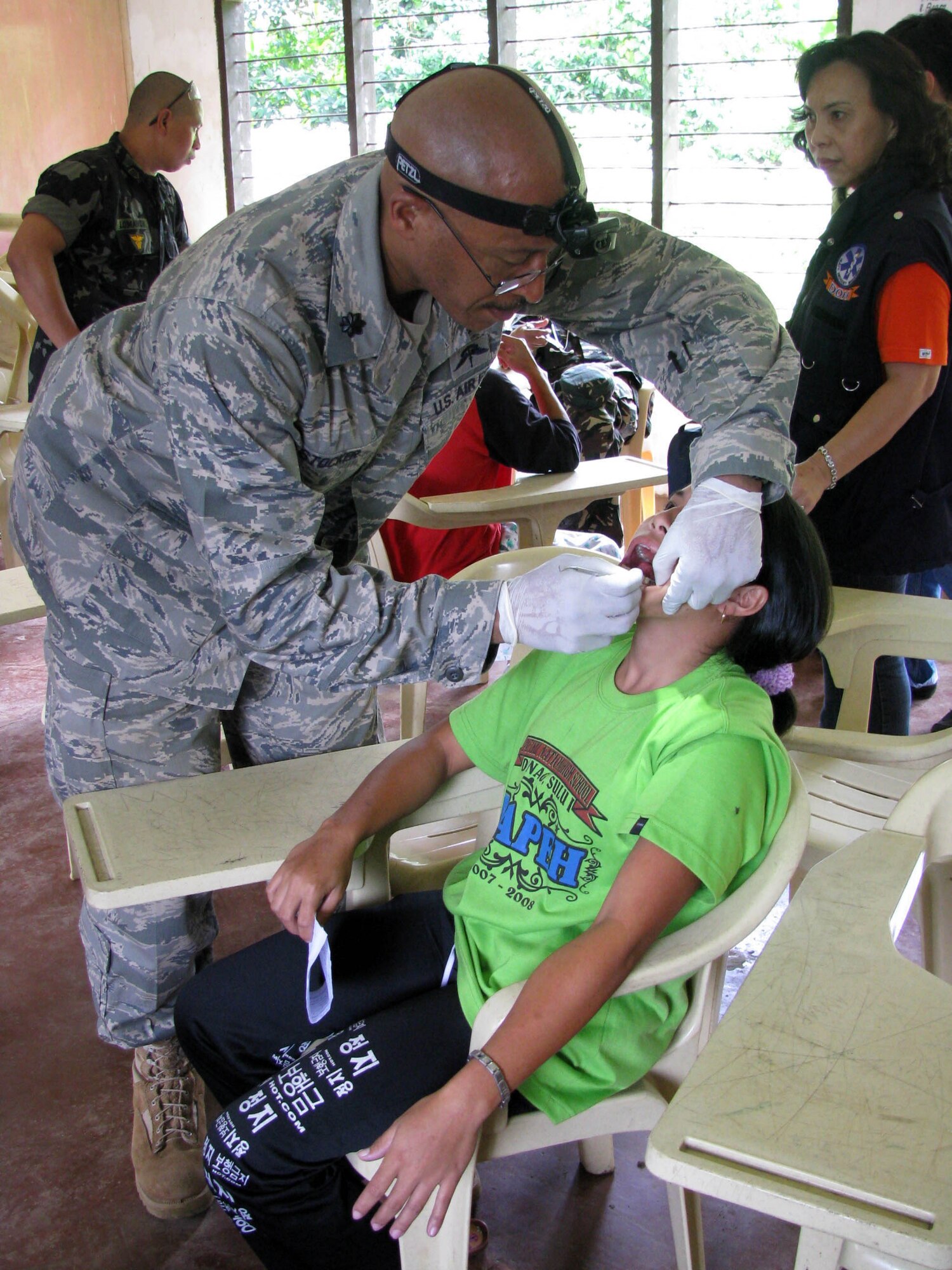 Lt. Col. Arnold Stocker extracts a tooth from a young girl during a Medical Civic Action Project Nov. 28, 2009, in Jolo, Philippines. Colonel Stocker is a nurse anesthetist assigned to Joint Special Operations Task Force-Philippines. (U.S. Navy photo/Lt.j.g. Theresa Donnelly)