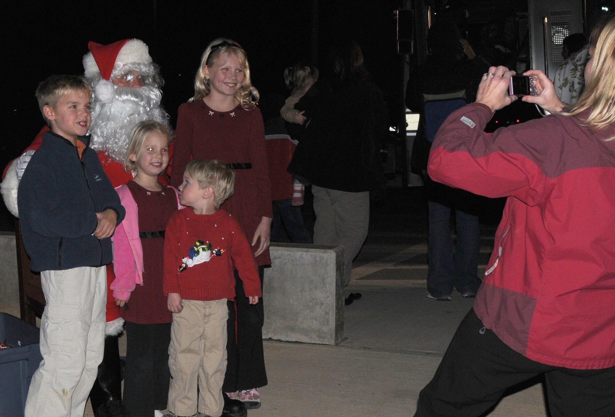 Stacey Turner, wife of Lt. Col James Turner, 39th Force Support Squadron commander, takes a photo of their children with Santa Claus during Incirlik’s tree lighting ceremony Thursday, Dec. 3, 2009 at the base chapel.  The tree lighting ceremony is held every year during the holiday season to bring Airmen and their families together by lighting the base Christmas tree, serving cookies and hot chocolate, and a special visit from Santa.  (U.S Air Force Photo/Senior Airman Ashley Wood)
