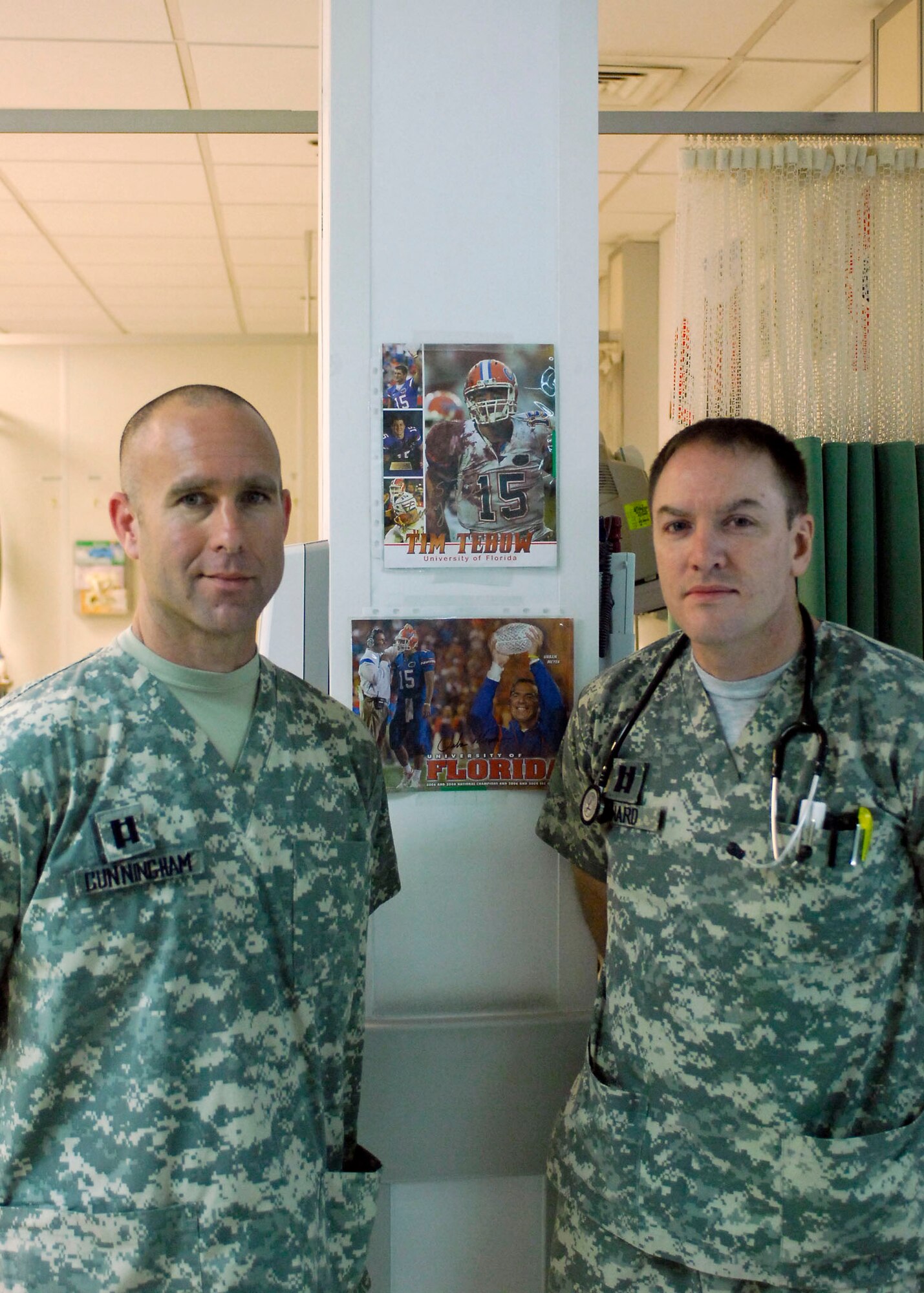 BAGRAM AIRFIELD, Afghanistan - Capts. Frank Cunningham and Matt Howard stand next to signed lithographs from University of Florida football head coach Urban Meyer and quarterback Tim Tebow.  Many NCAA teams, especially those from the South
Eastern Conference sent memorabilia to the Craig Joint Theater Hospital here
to brighten the spirits of the wounded servicemembers and staff.  (U.S. Air Force photo/Senior Airman Felicia Juenke)