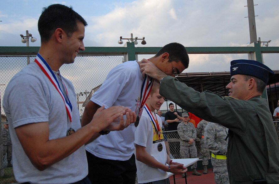 Col. Lenny Richoux, 18th Wing vice commander, awards a first-place medal to Staff Sgt. Tomas Sanchez, 18th Civil Engineer Squadron, for completing the Combined Federal Campaign 5K fundraiser run Dec. 4 in less than 17 minutes. More than 175 people on island participated in thefundraiser run and raised more than $1,200 for this year’s campaign. The top finishers were: Staff Sgt. Tomas Sanchez, 18th Civil Engineer Squadron, with a 16:56 run time in the males category and Yoko Stevens with a 19:27 run time in the female category. Brad Davies, son of Col. Kirk Davies from the 18th Wing Judge Advocates office, Maj. Alan Payton, 82nd Reconnaissance Squadron, Capt. Emily Newman, 18th Aeromedical Evacuation Squadron and Tech. Sgt. Debra Gililland-Swartz, 18th Maintenance Group, were also among the top three finishers. (Air Force/Staff Sgt. Jason Lake) 
