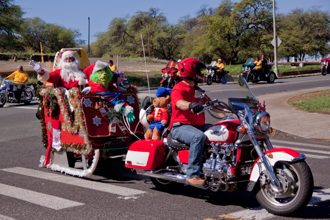 HONOLULU -- Santa waves to bystandres as he rides into Kapiolani Community College during the 35th Annual Street Bikers United Toy Run Dec. 6.