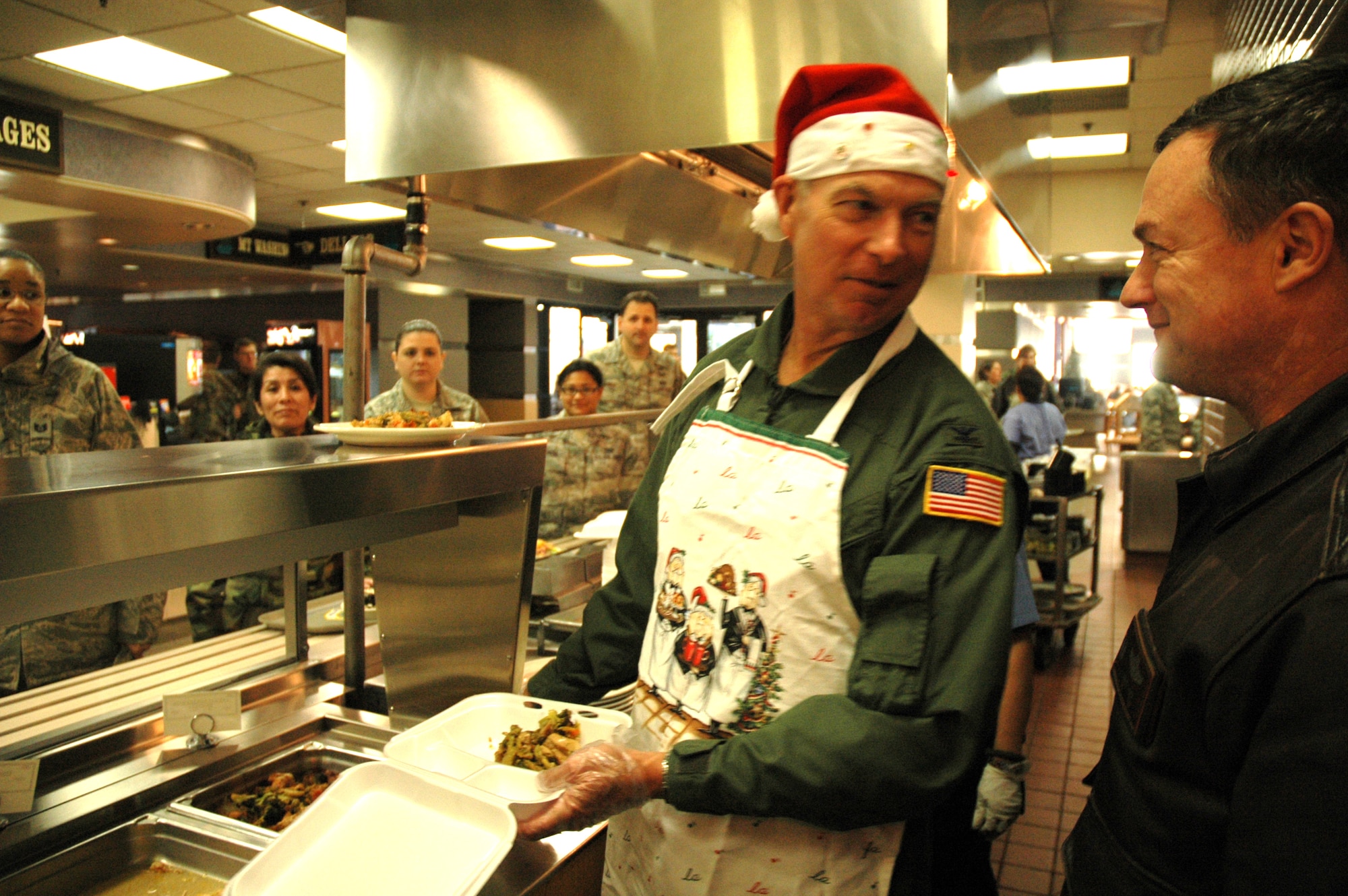 MCCHORD AIR FORCE BASE, Wash.- Col. William Flanigan, left, 446th Airlift Wing commander here, sneaks a quick word in with 446th Operations Group commander, David Pavey, while serving lunch to people of the 446th AW at the Olympic Dining Facility here during the December Reserve weekend. This is one way higher leadership shows its appreciation for all of the hard work and dedication from the members of the wing over the past year.(U.S. Air Force photo/Master Sgt. Jake Chappelle)