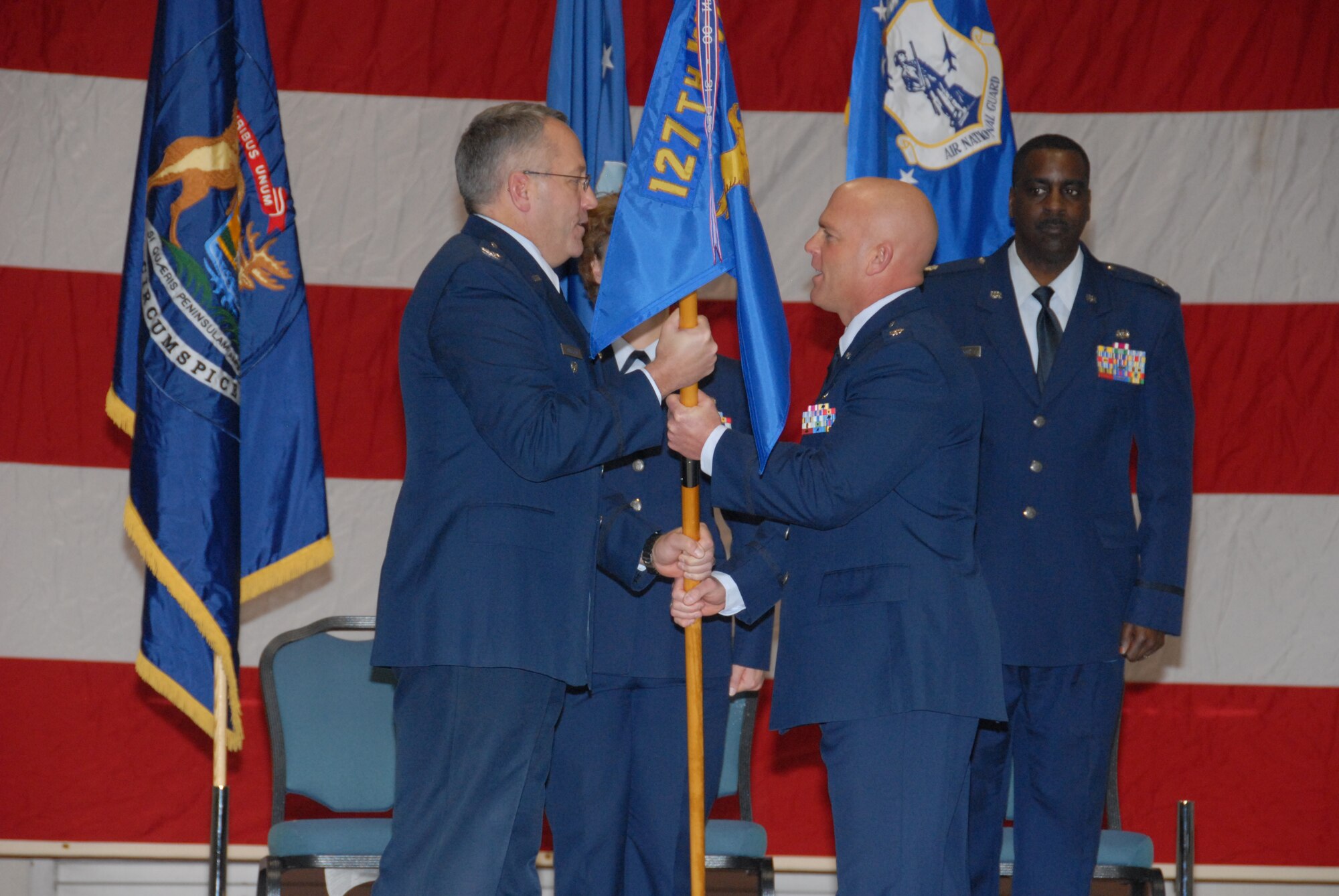 Lt. Col. Mac A. Crawford (right, front) takes the 127th Mission Support Group flag from  127th Wing Vice Commander Col. David Augustine, and officially assumed command of the group of just over 500 Airmen including the Civil Engineering, Security Forces, Logistics Readiness, Communications and Force Support squadrons. during a change of command ceremony  on Saturday, December 5.(U.S. Air Force photo by Master Sgt. Clancey Pence)