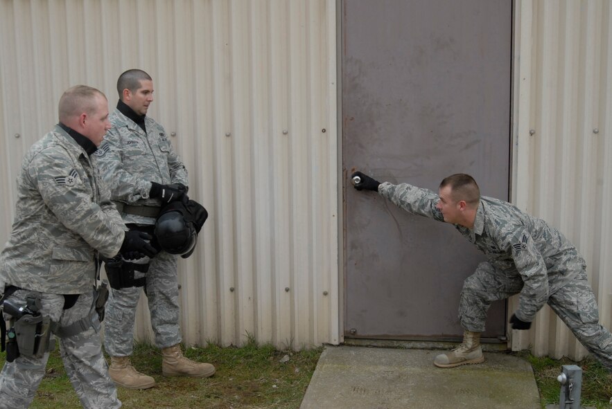 KUNSAN AIR BASE, Republic of Korea -- Senior Airman Robert Davis and Staff Sgt. Jeremy Johnson watch as instructor, Senior Airman Kolin Jones, demonstrate the proper way to enter the facility during simulated rounds training here Dec. 2. The Simulated rounds training taught new Security Forces members proper ways to clear a building by engaging them with various situations. After each scenario the instructors correct mistakes, demonstrate the proper techniques, and highlight good methods applied. (U.S. Air Force photo/Staff Sgt. Darnell T. Cannady)