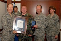 Col. Kevin W. Bradley, 174 Fighter Wing Commander, Chief Master Sgt.  David D. Heckman, 174FW Command Chief Master Sgt. and Master Sgt. Mary A. Oaksford, 174FW First Sergeant present the Hometown Heroes Plaque to SSgt Ricky Best. SSgt Best is a photographer assigned to the 174th Fighter Wing Public Affairs office and has been deployed overseas in support of Operation Enduring Freedom. This presentation took place at Hancock Field Air National Guard Base on 6 December 2009.
