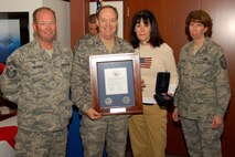 Chief Master Sgt.  David D. Heckman, 174FW Command Chief Master Sgt. and Master Sgt. Mary A. Oaksford, 174FW First Sergeant present the Hometown Heroes Plaque to Col. Kevin W. Bradley, 174 Fighter Wing Commander, and his wife, Karen. Col. Bradley has deployed many times most recently in 2007 in support of Operation Iraqi Freedom. This presentation took place at Hancock Field Air National Guard Base on 6 December 2009. 