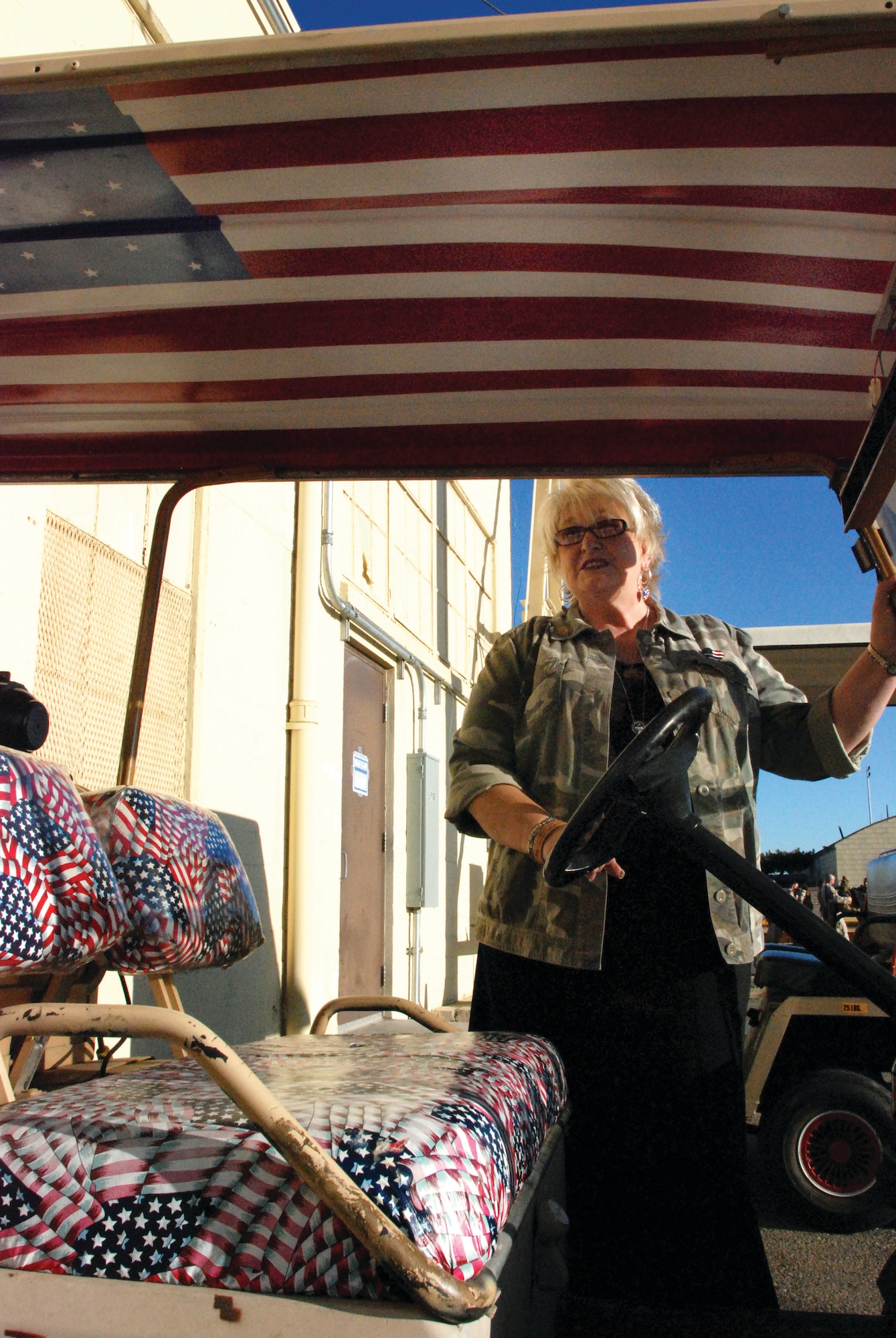 Mrs. Laura Froehlich boards her personalized golf cart to drive to the commercial jet Nov. 17 to say goodbye to the 108 I Marine Expeditionary Force Marines who departed for deployment from the March ARB deployment hangar. (U.S. Air Force photo by Megan Just)